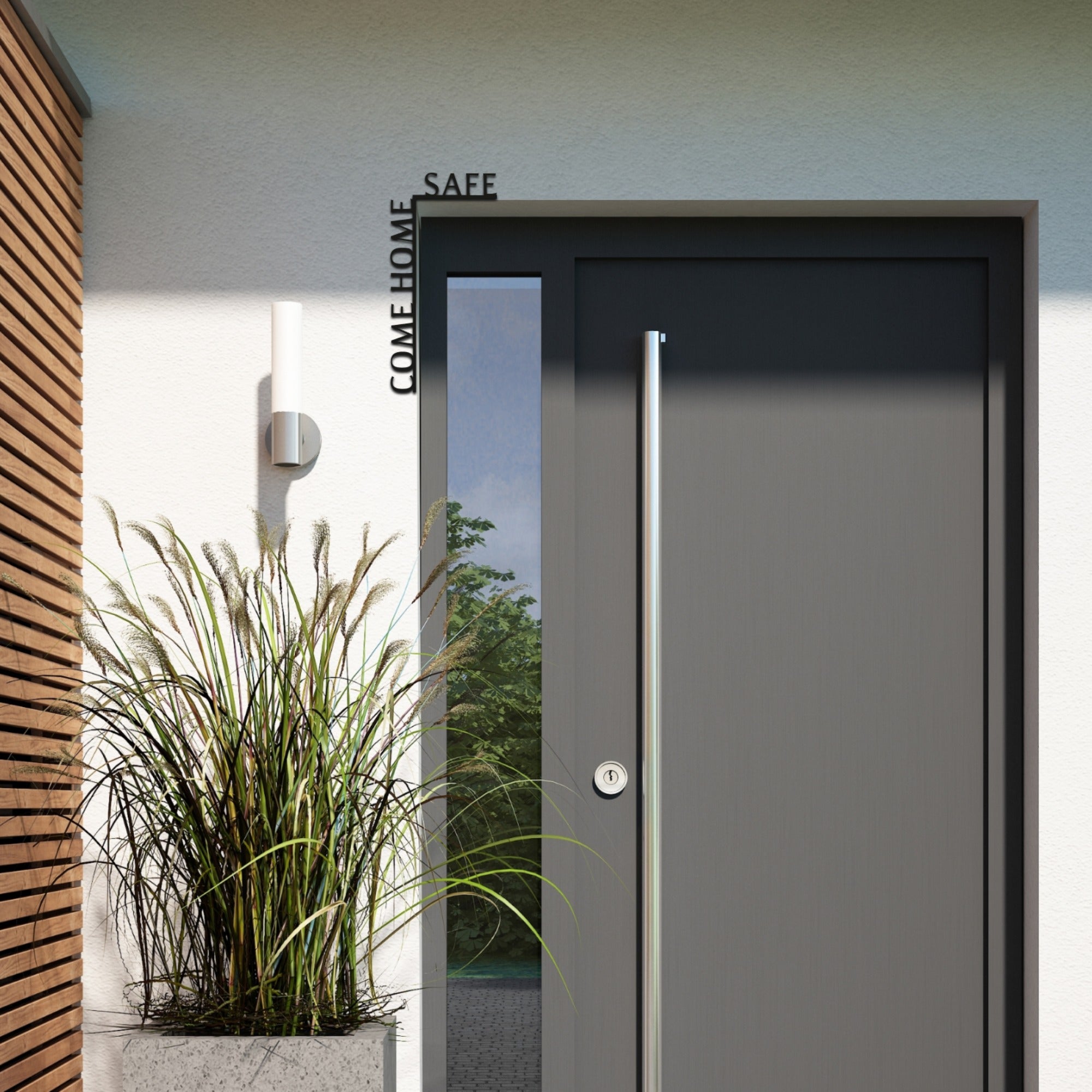 Modern door with decorative text above it, flanked by plants and a wall light.