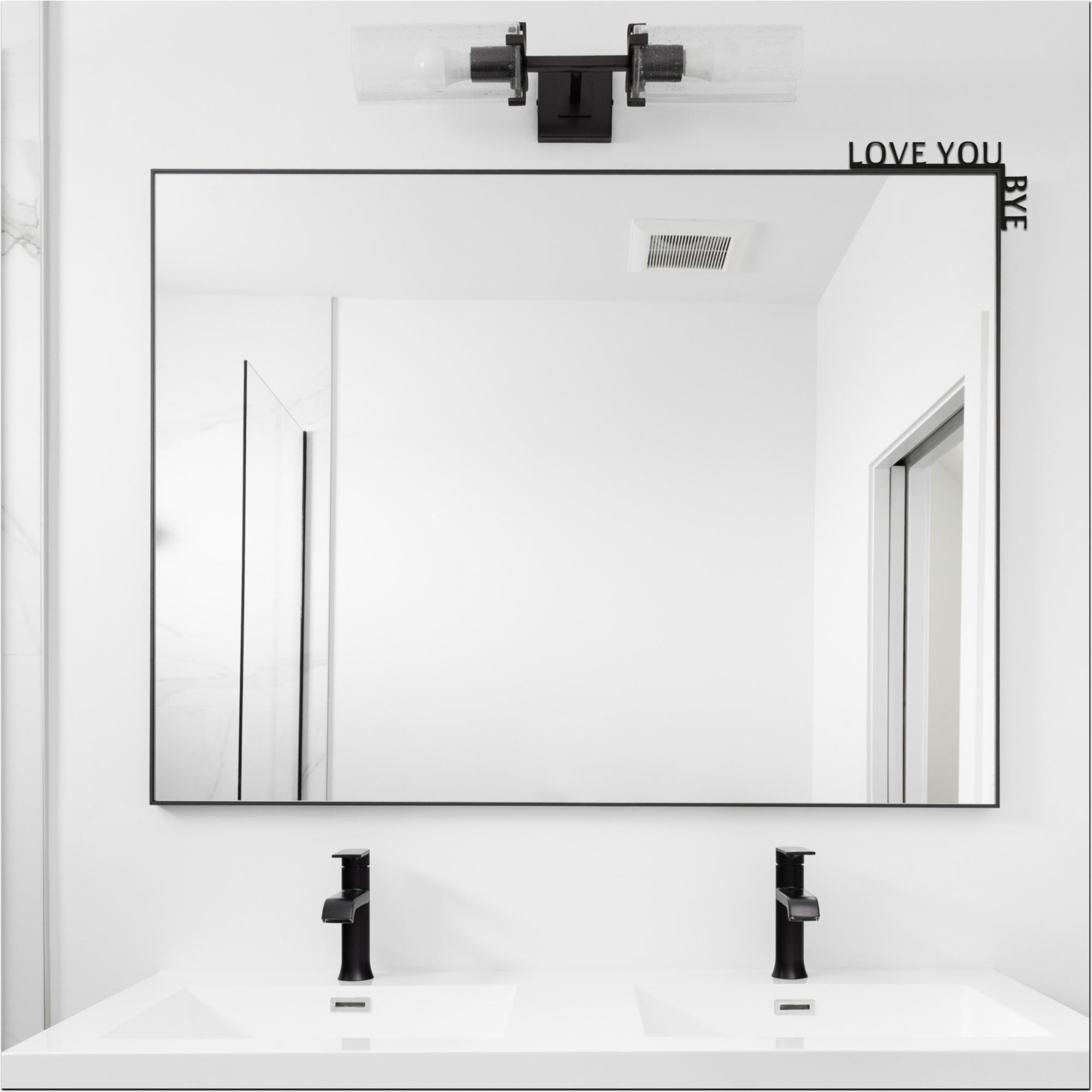 Bathroom with a large mirror, sink, and text 'LOVE YOU BYE' on the wall.