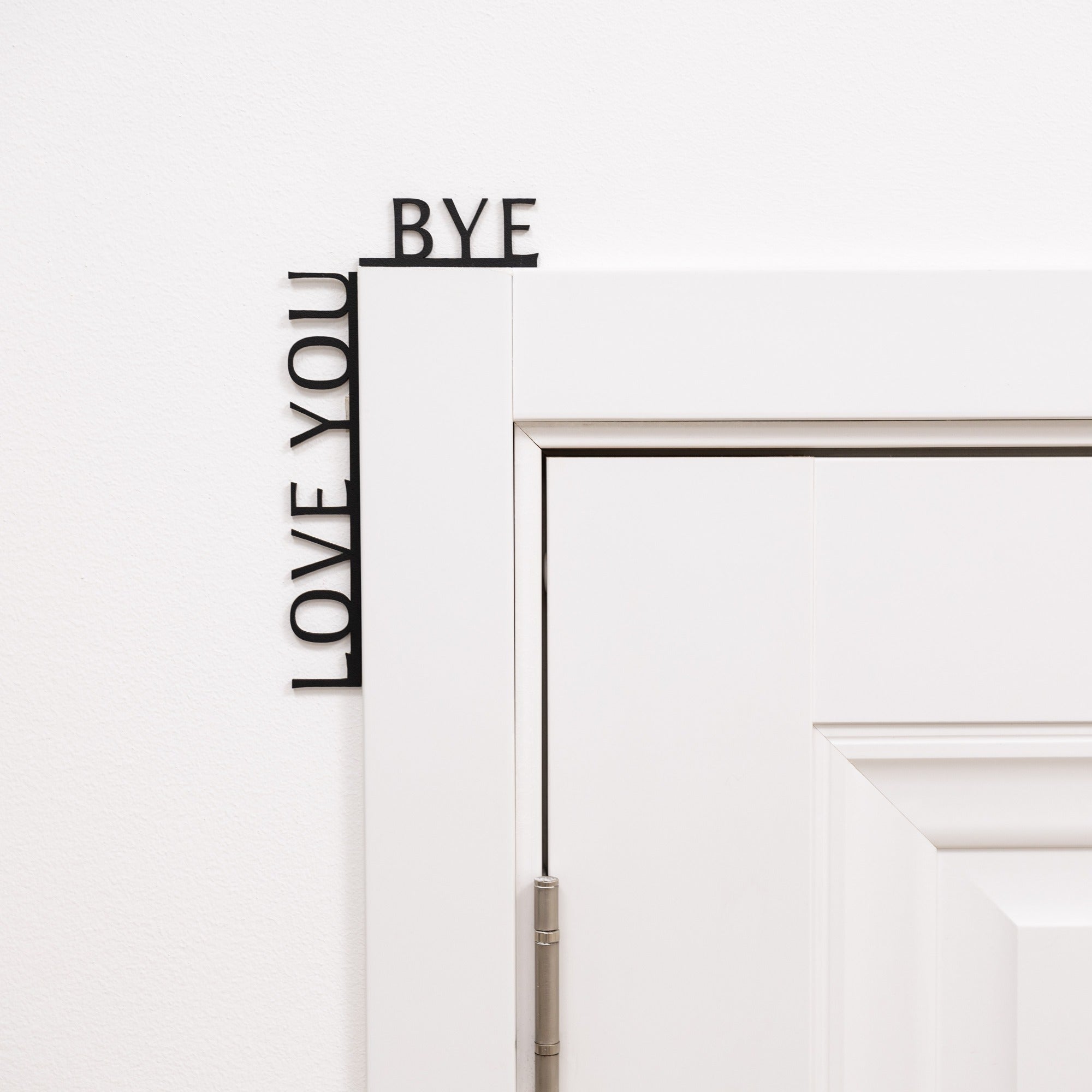 Decorative wall decal with 'LOVE YOU' and 'BYE' text on a white wall.