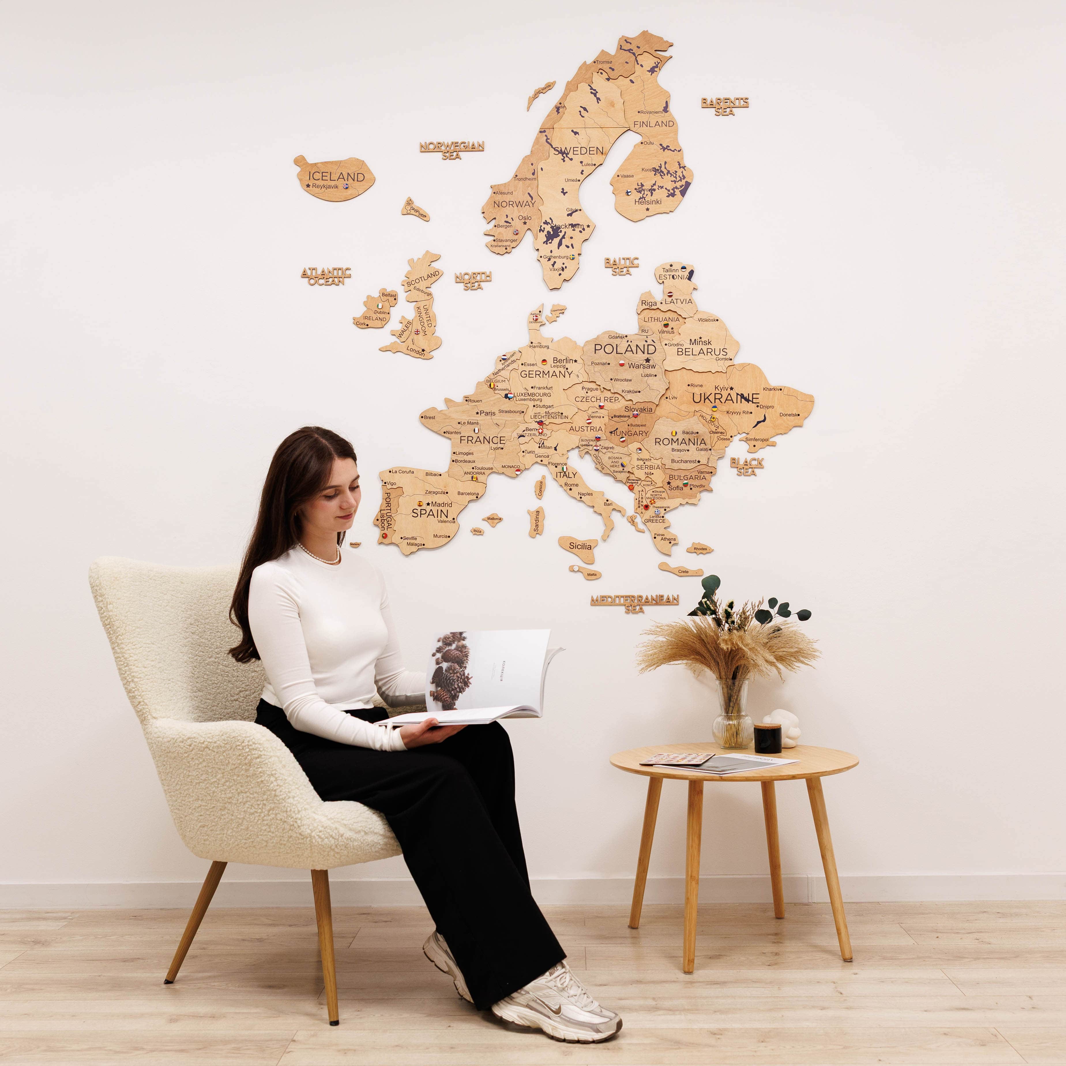 Woman sitting in a chair with a wooden world map on the wall