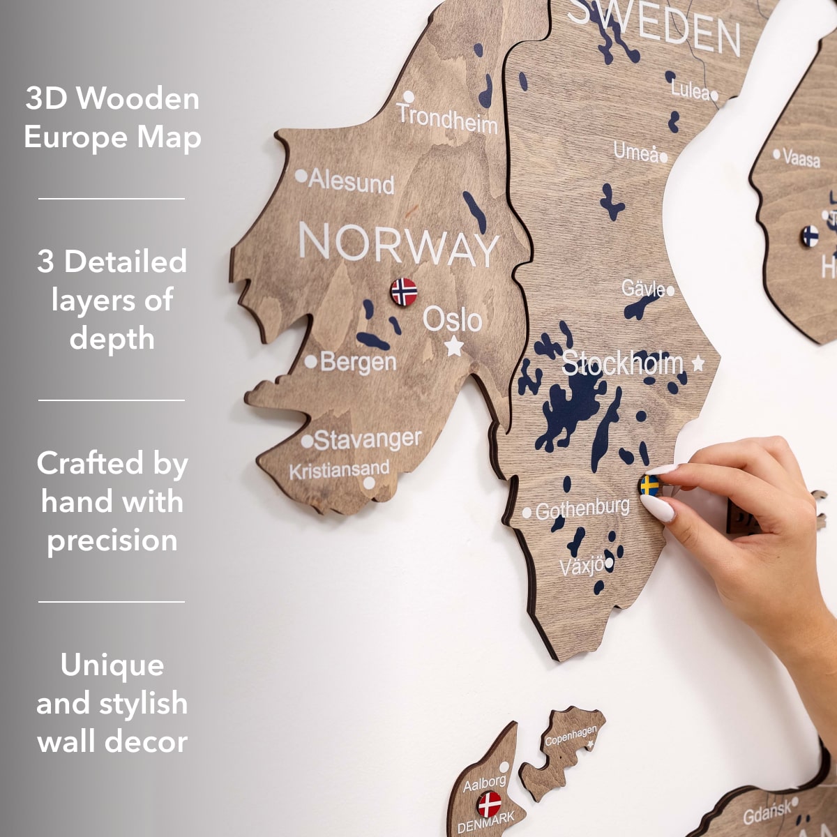 3D wooden Europe map with detailed layers, hand holding a marker, on a light gray background.