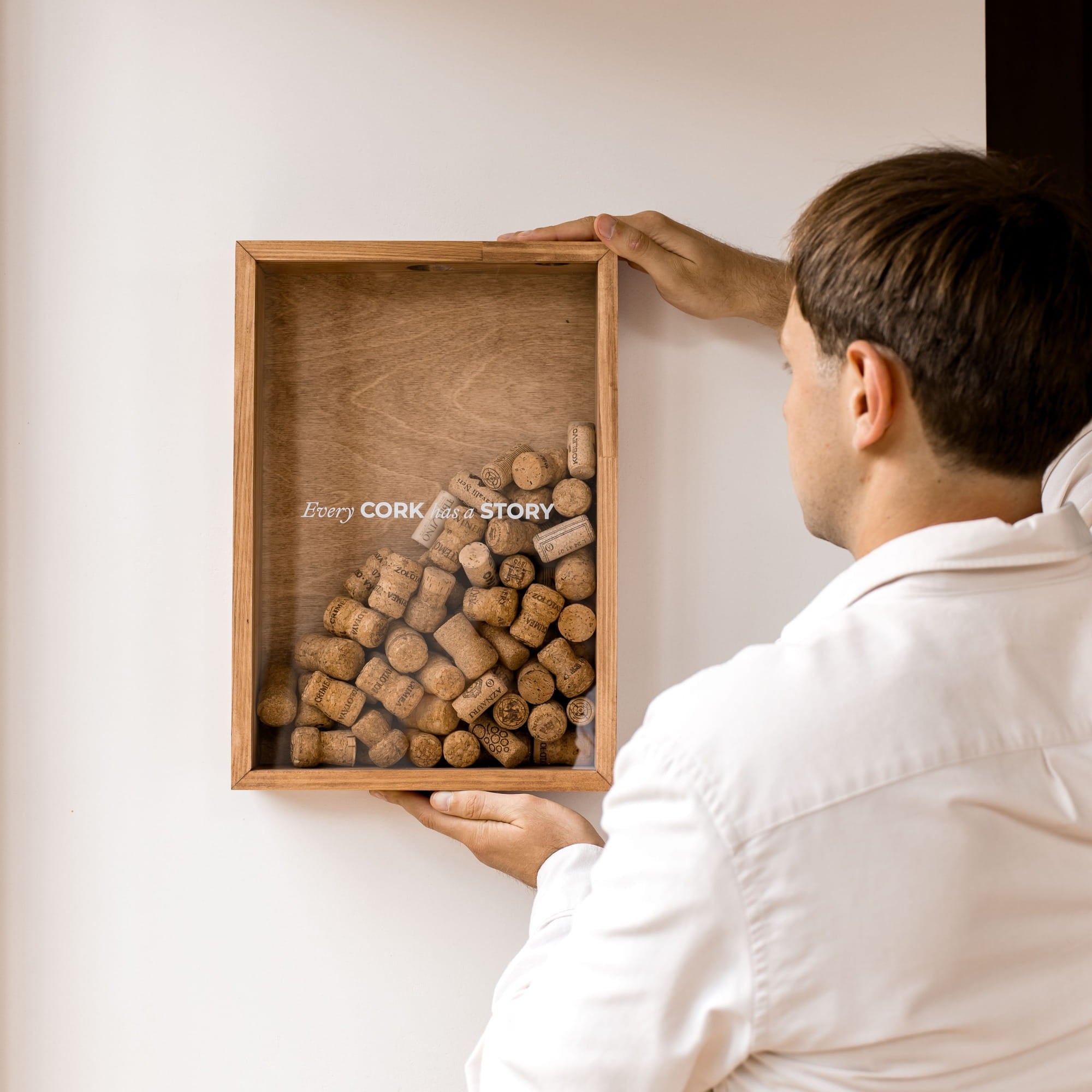 The box contains many wine corks under a clear glass front, with the text 'Every CORK and STORy' printed on the glass.