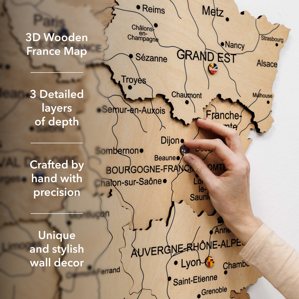 Wooden map of France with a hand pointing to Dijon, labeled '3D Wooden France Map' with text about layers and craftsmanship.