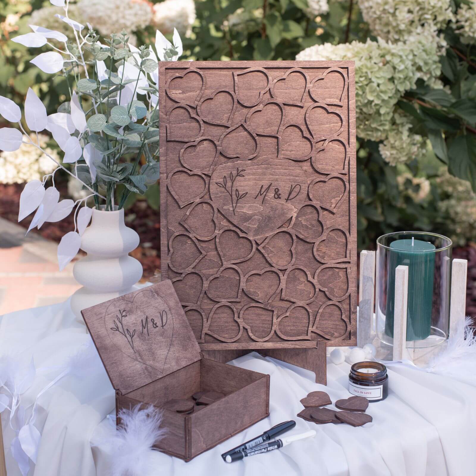 A wooden rectangular guest book with a geometric heart pattern design, displayed at a wedding event.