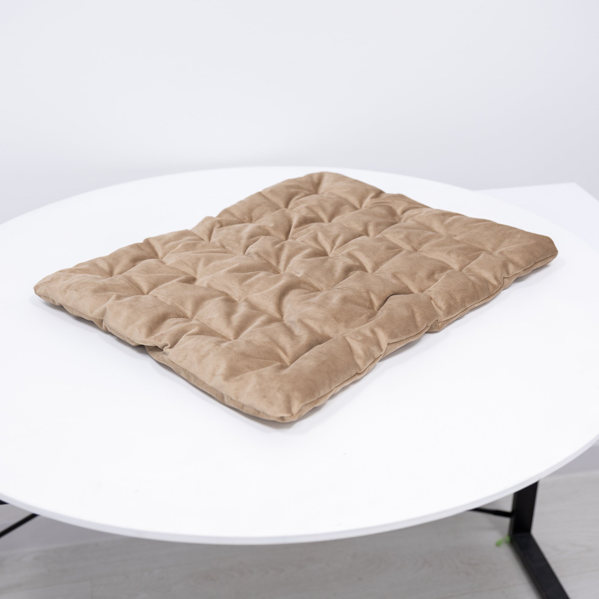 Beige quilted mat on a white round table
