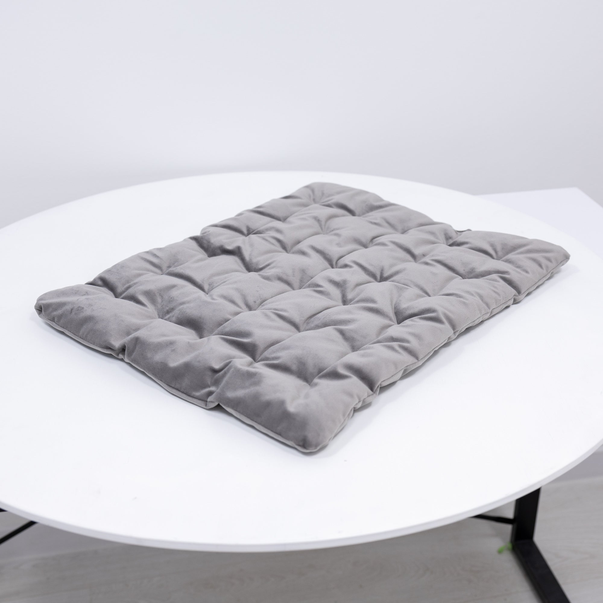 Gray quilted cushion on a white round table