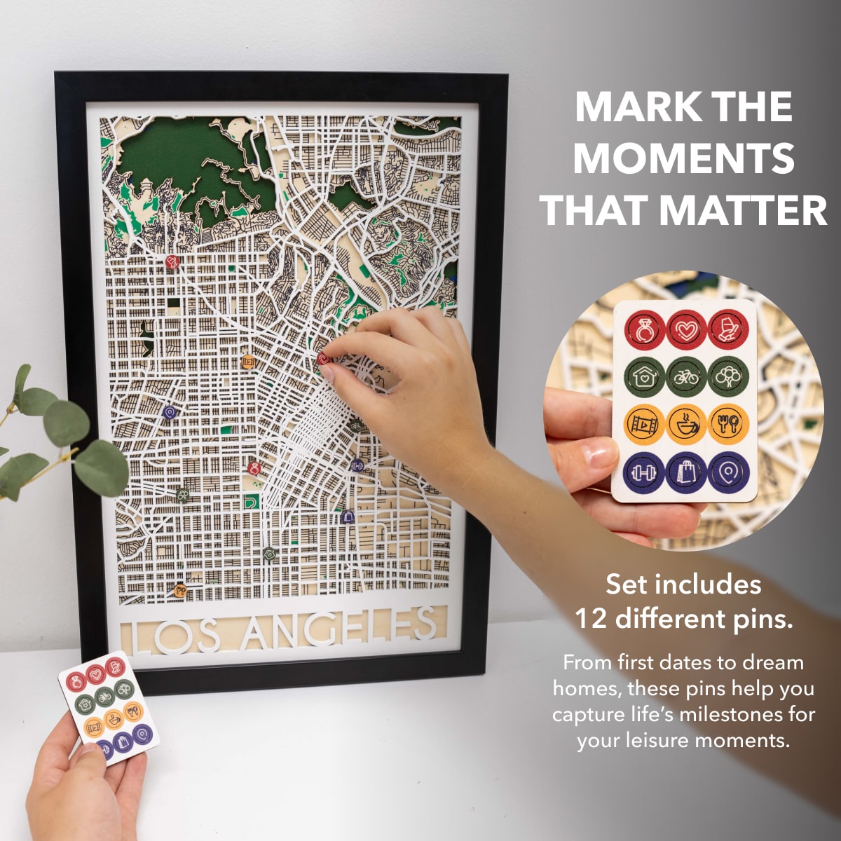 Framed map of Los Angeles with decorative pins on a white surface.
