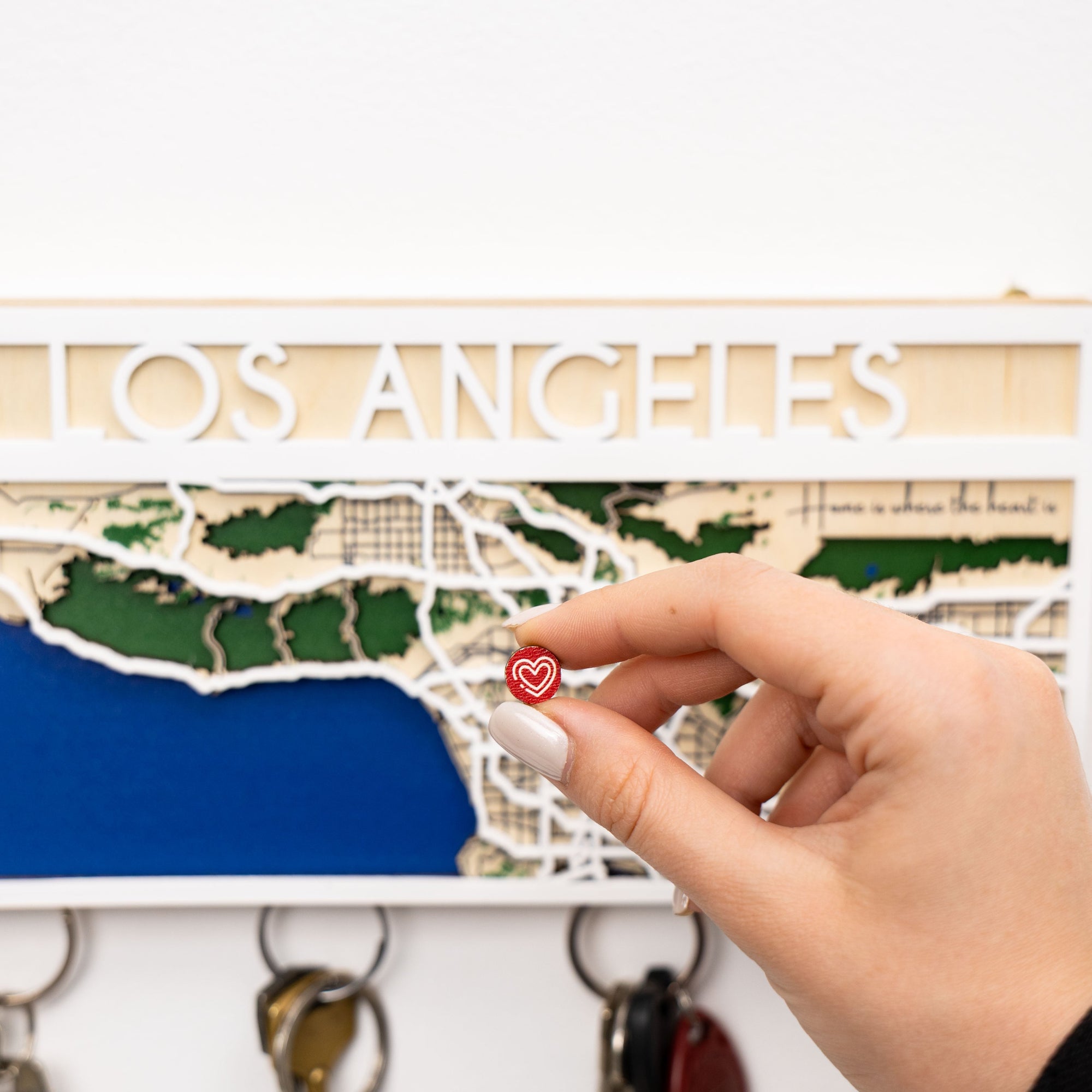 Map of Los Angeles with a hand holding a red heart keychain