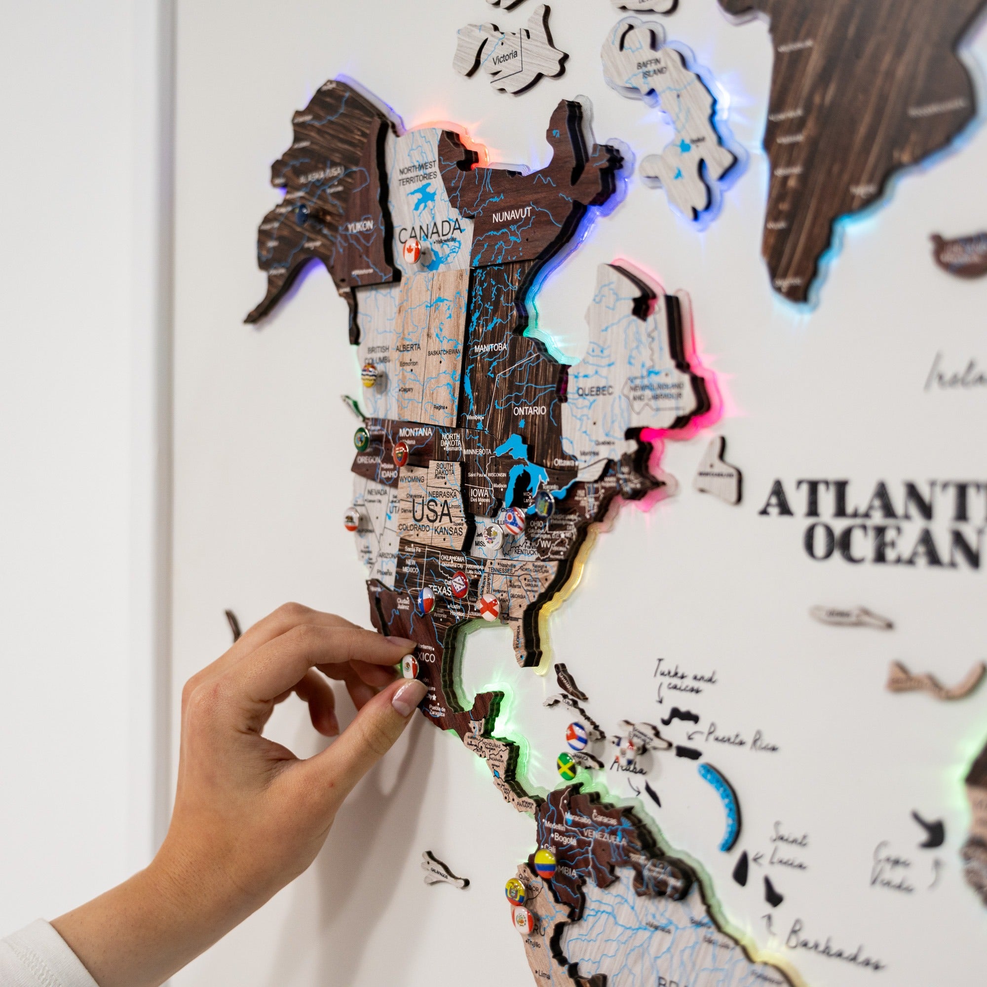 World map with glowing edges on a white background, held by a hand.