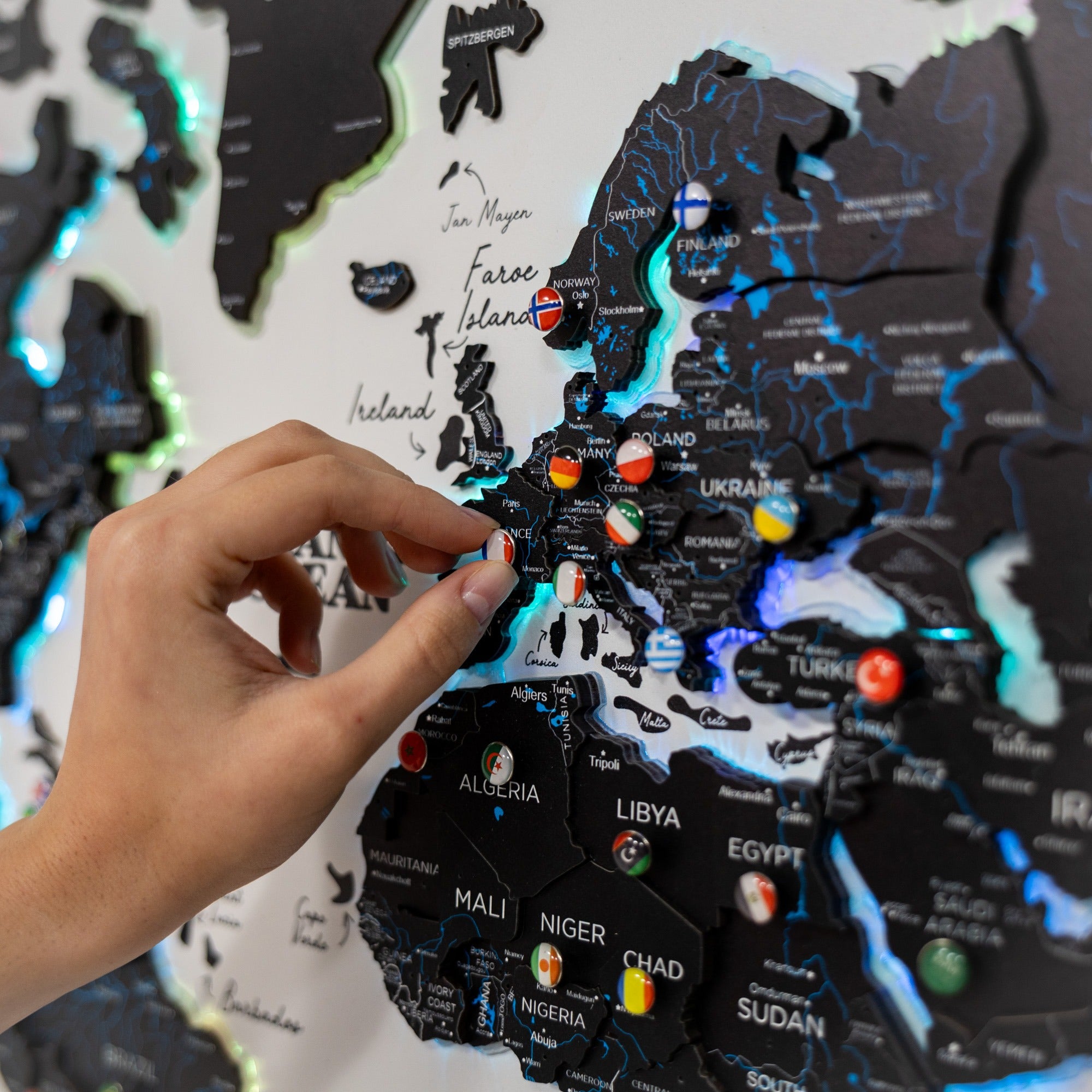 Map of Europe with country flags and a hand pointing to a specific location.