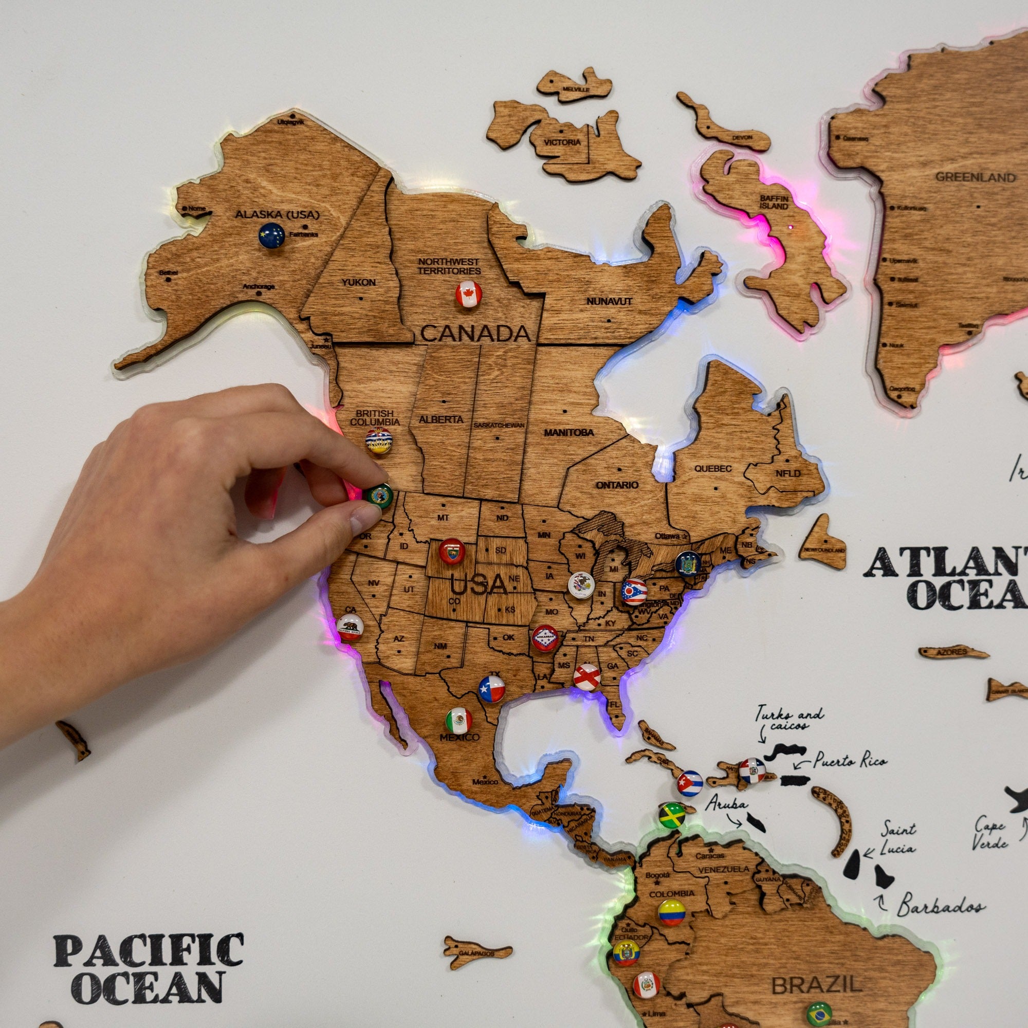 Wooden world map with LED lights and a hand interacting with it