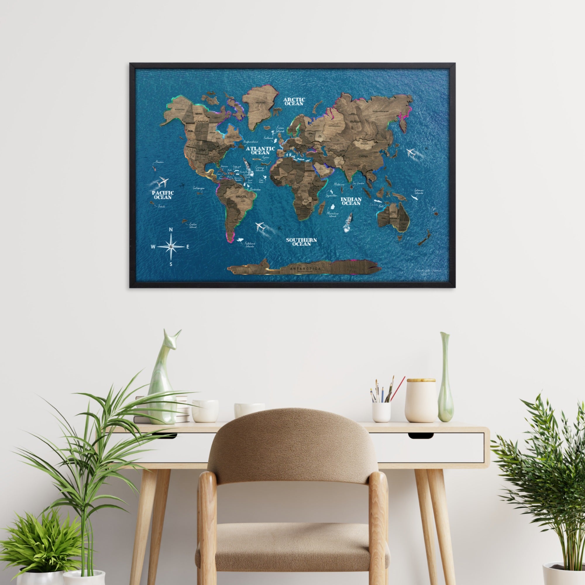 World map poster on a wall above a desk with plants and a chair.