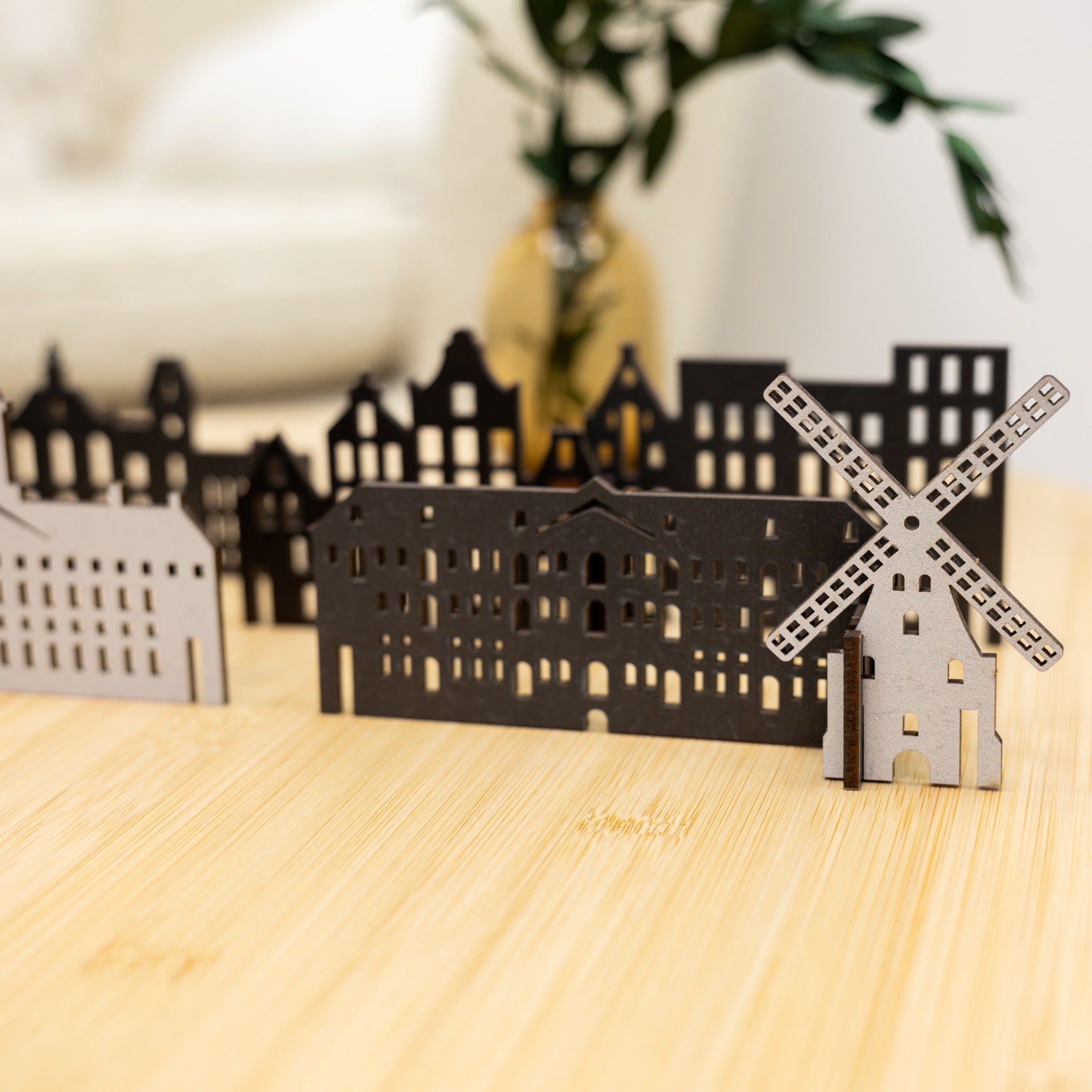 Model of a windmill and buildings on a wooden surface with a blurred background