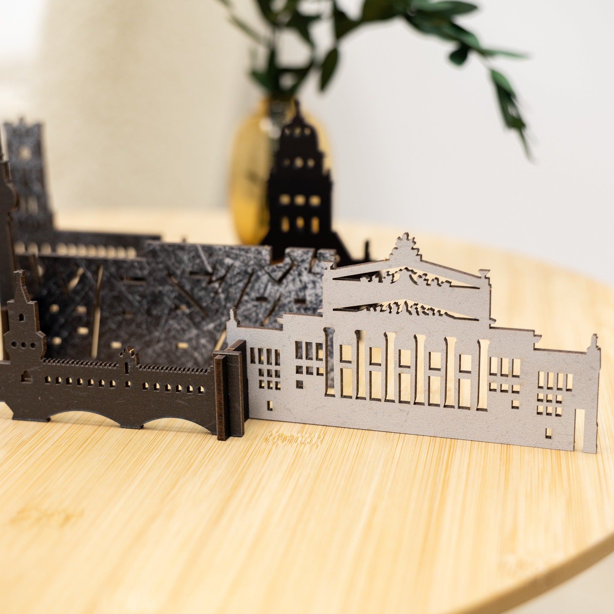 3D architectural models of buildings on a wooden surface with a blurred background