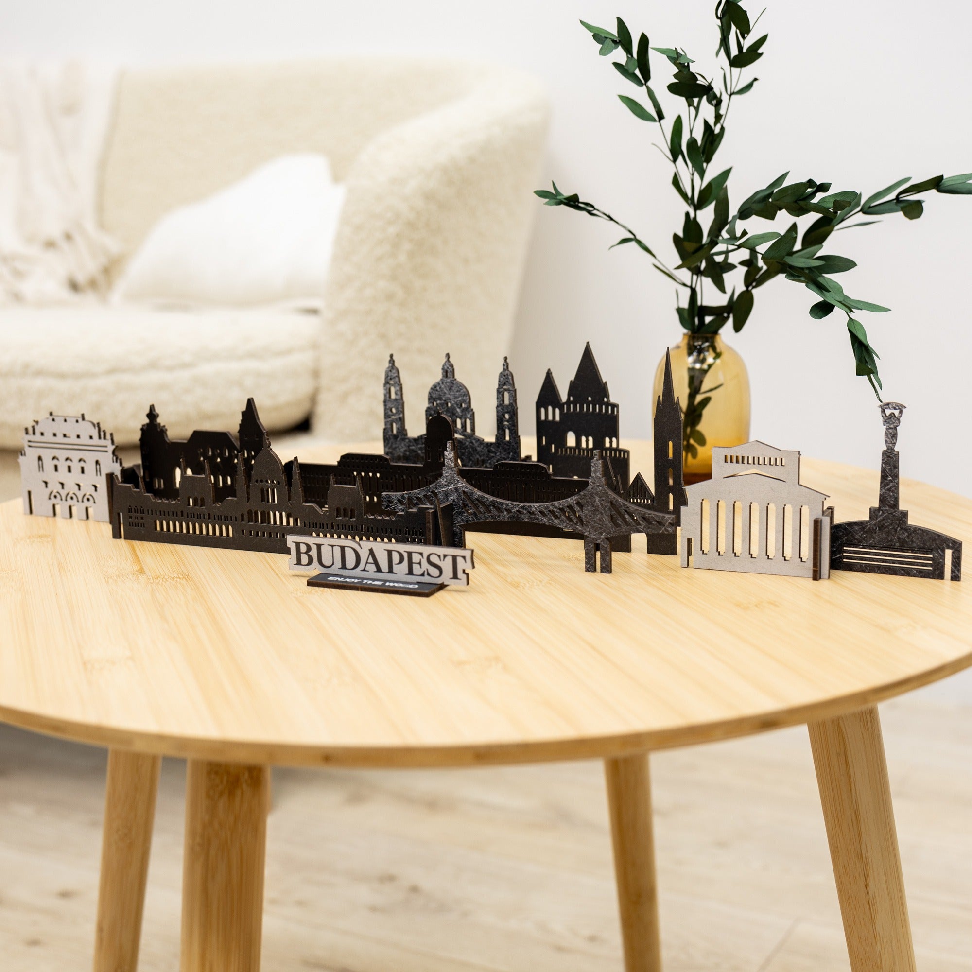 Model of Budapest skyline on a wooden table with a plant and cushions in the background