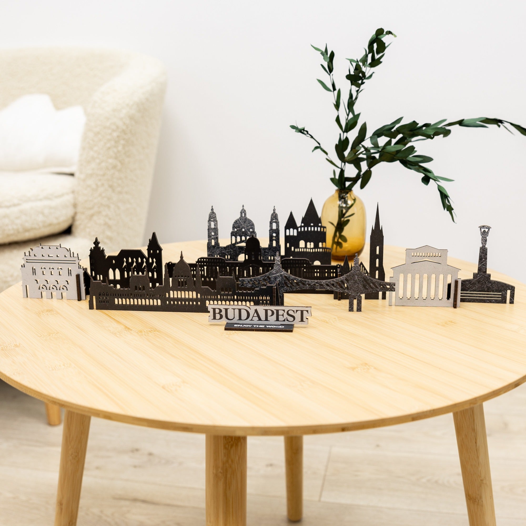 Decorative cityscape model of Budapest on a wooden table with a plant in the background.