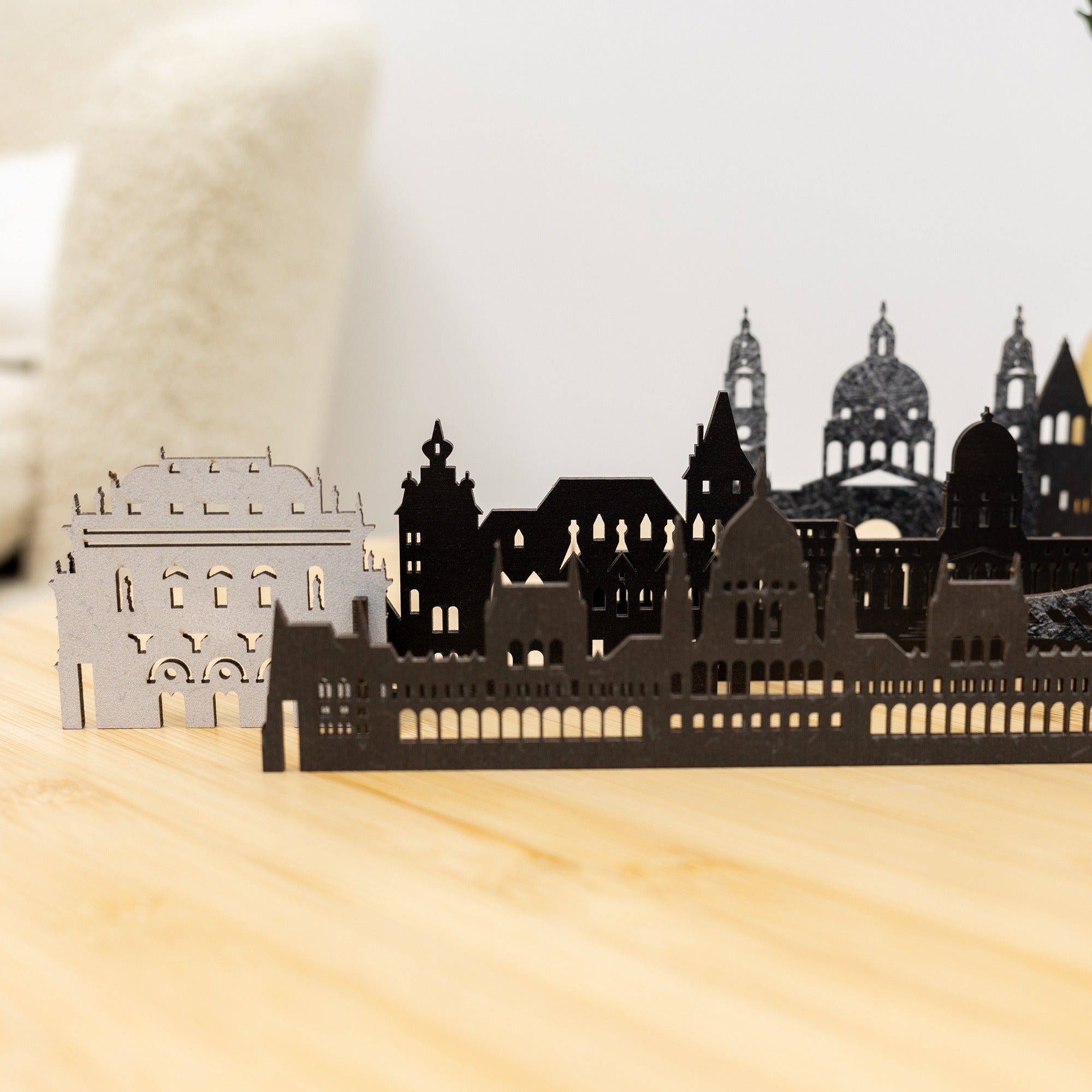 Black metal cityscape model on a wooden surface