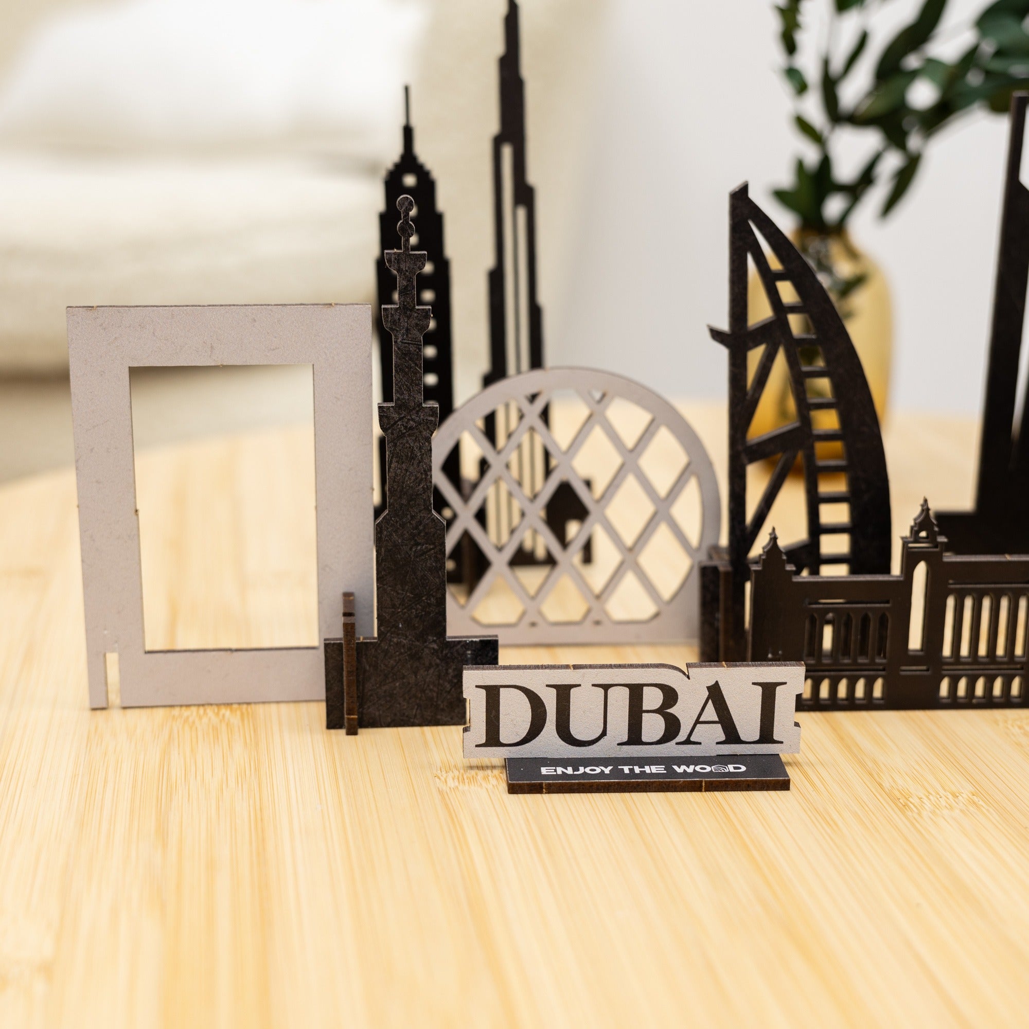 Model of Dubai landmarks on a wooden surface with 'Dubai' sign