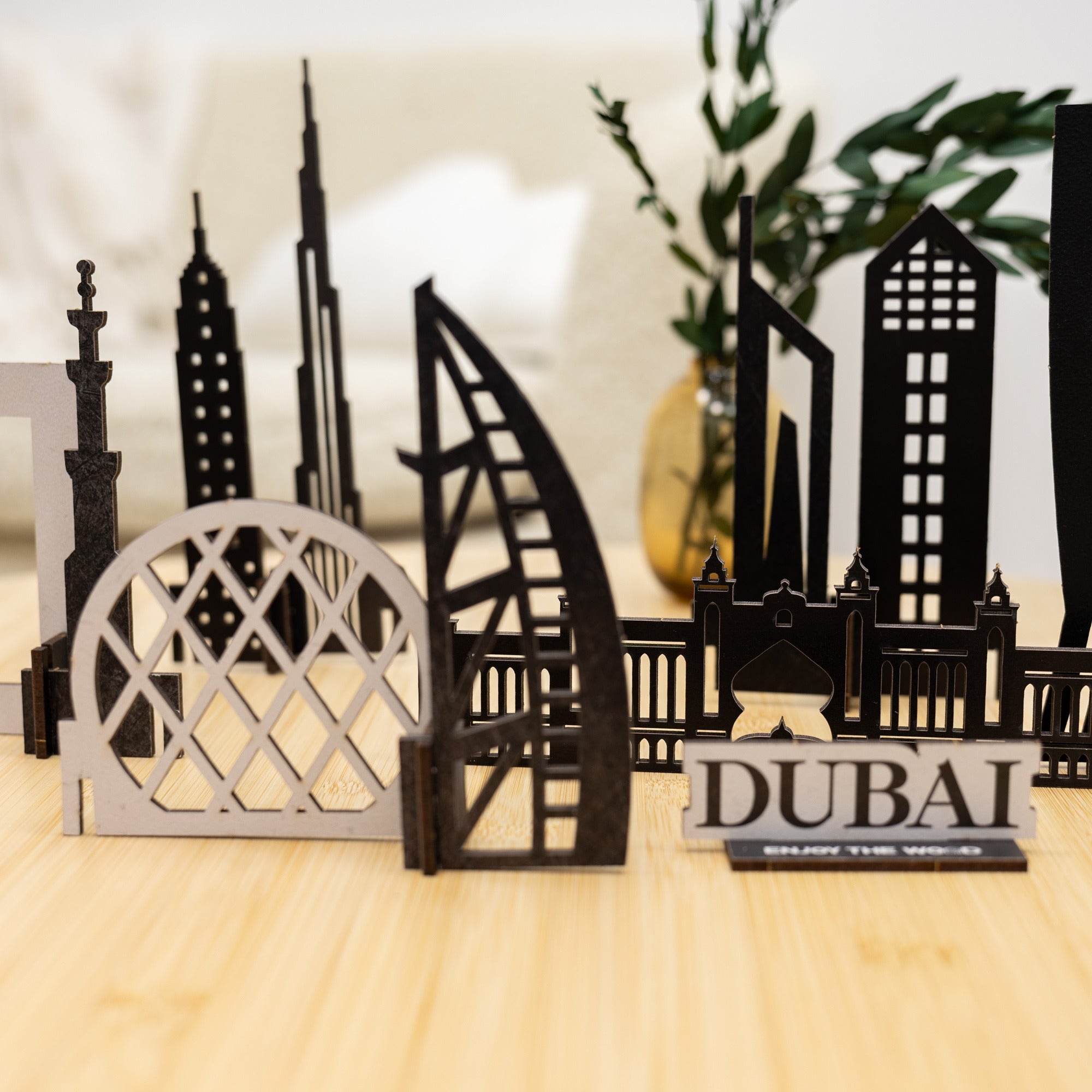 Model of Dubai skyline with 'Dubai' sign on a wooden surface