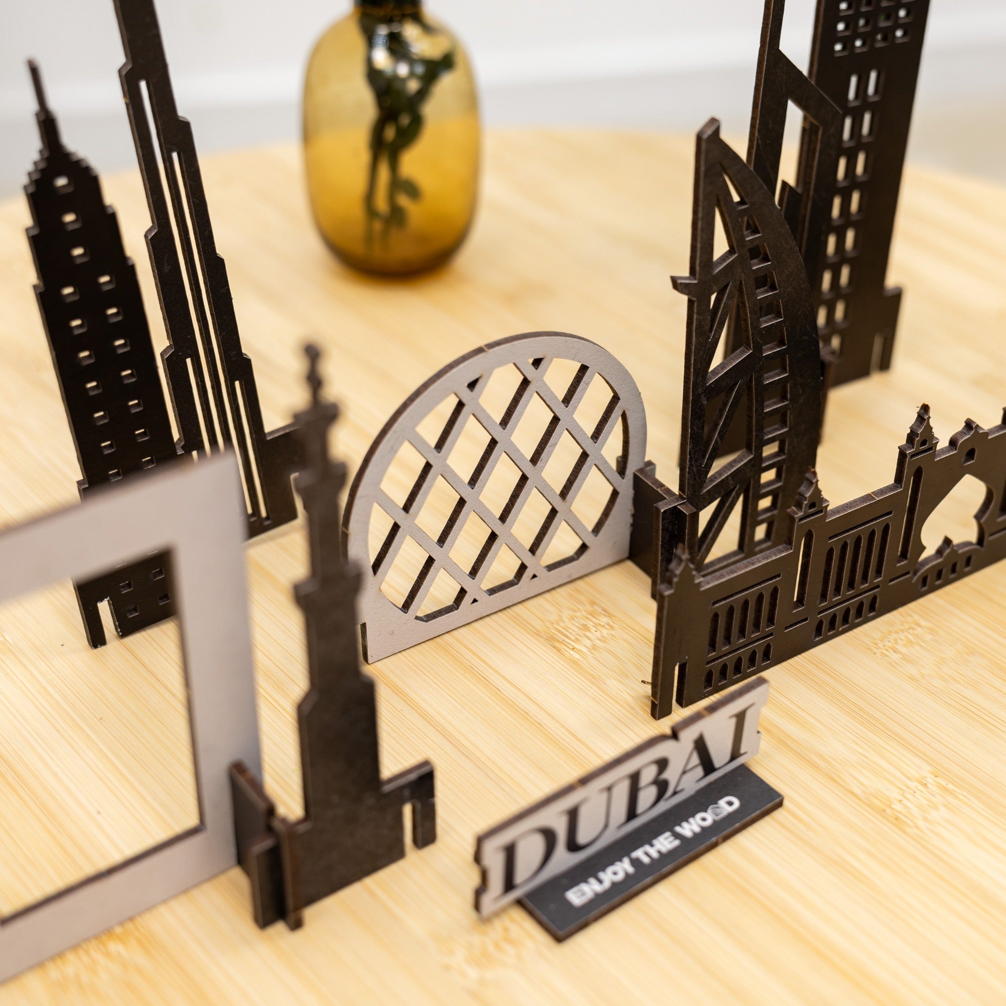 Model of Dubai skyline with 'Dubai' sign on a wooden surface