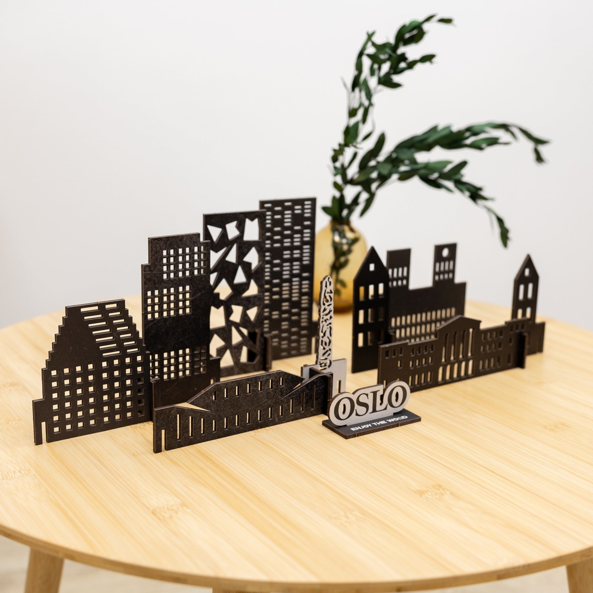 Black metal cityscape model on a wooden table with 'Oslo' sign