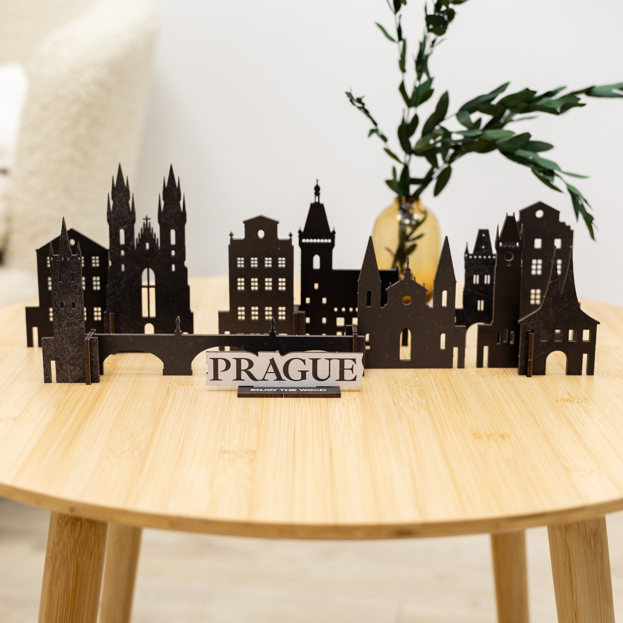 Black Prague cityscape model on a wooden table with a plant in the background