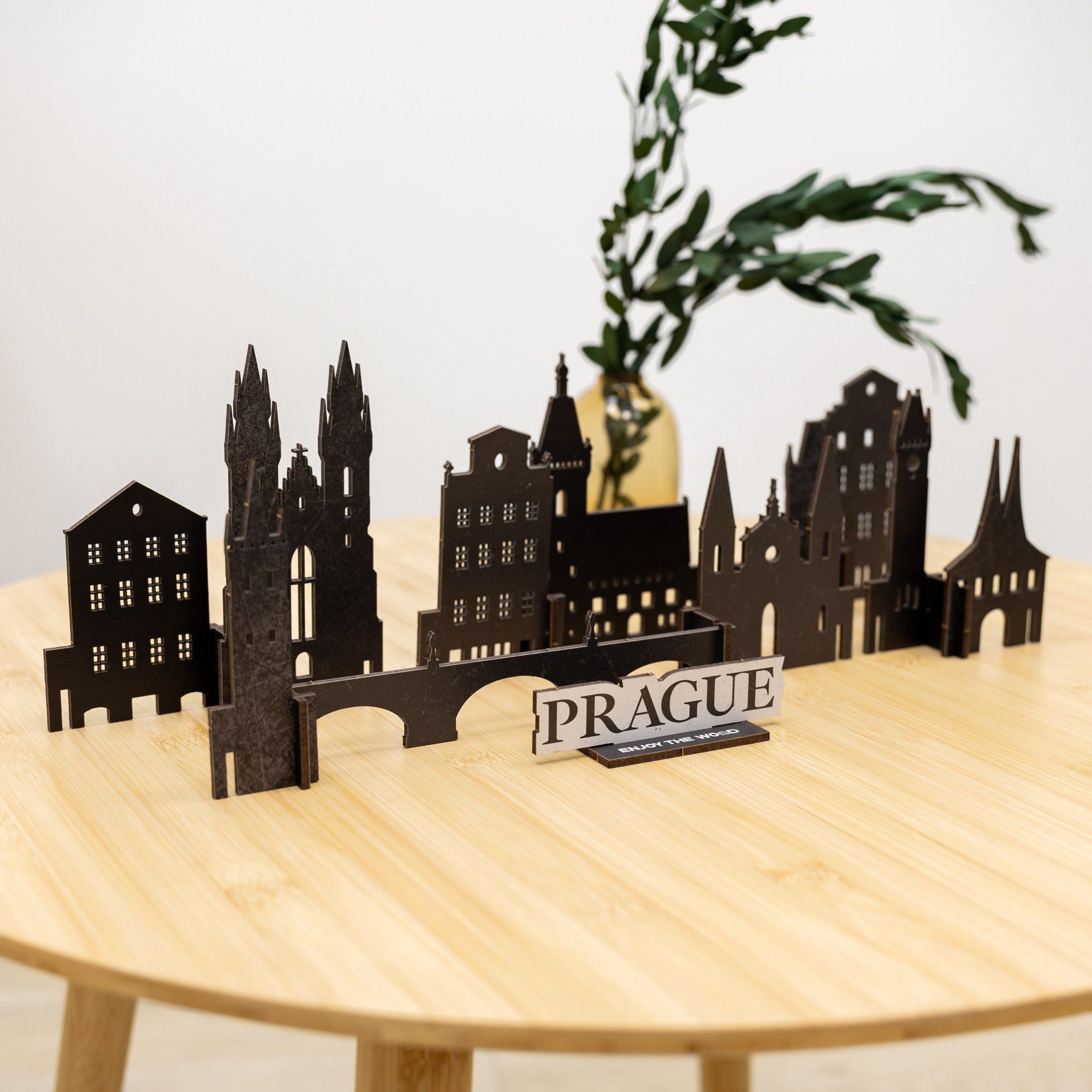Model of Prague skyline on a wooden table with a plant in the background