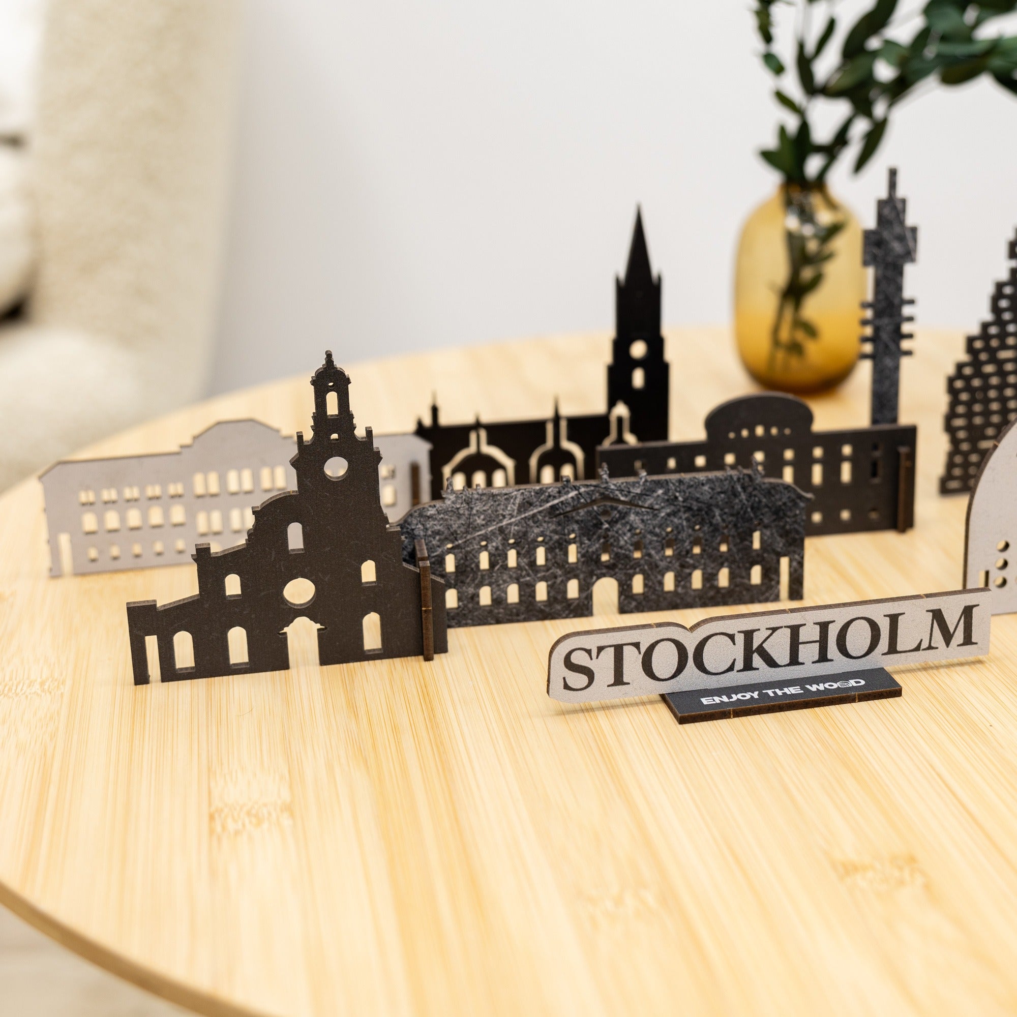 Metallic cutout of Stockholm cityscape on a wooden surface with 'Stockholm' label