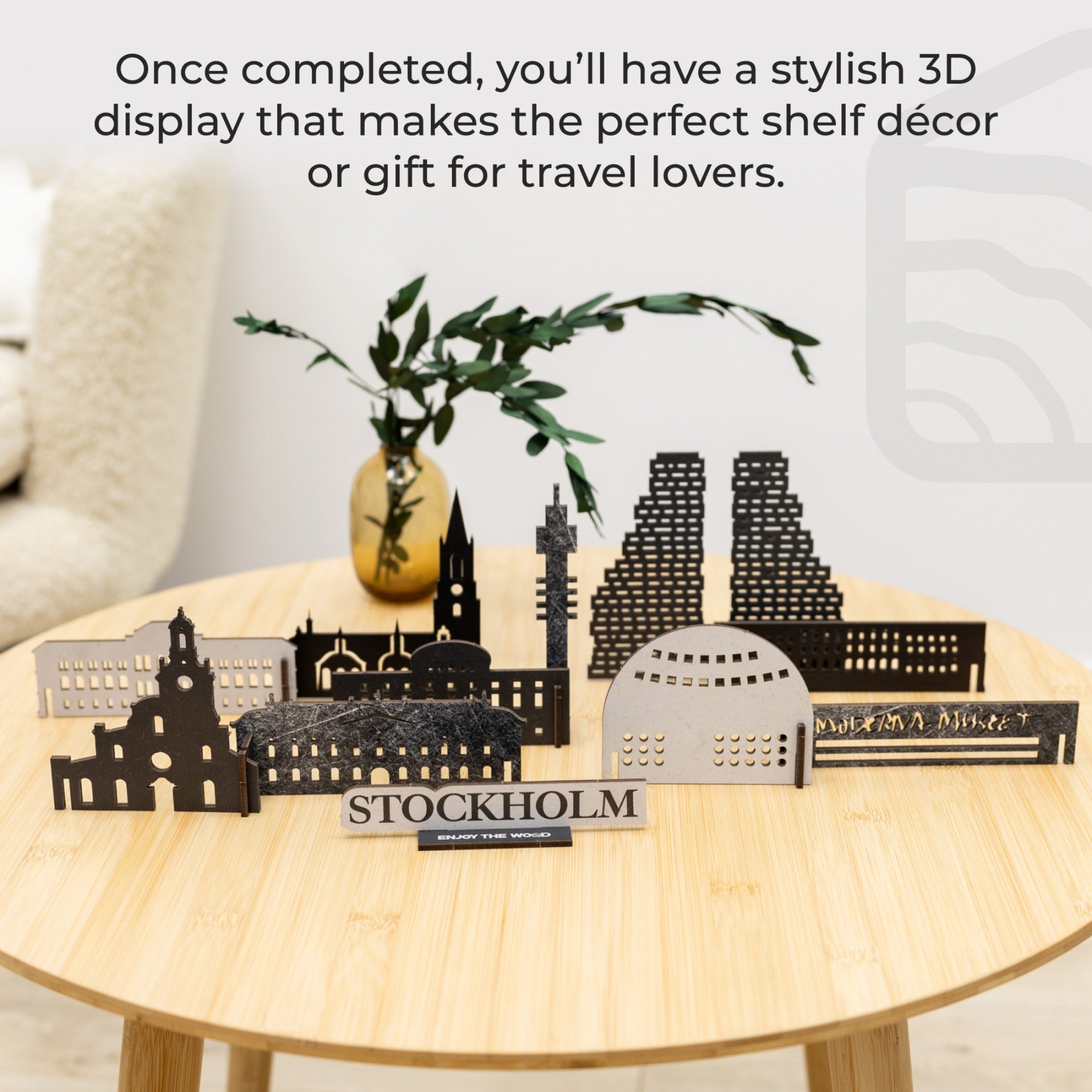 3D metal models of Stockholm landmarks on a wooden table with decorative plants.