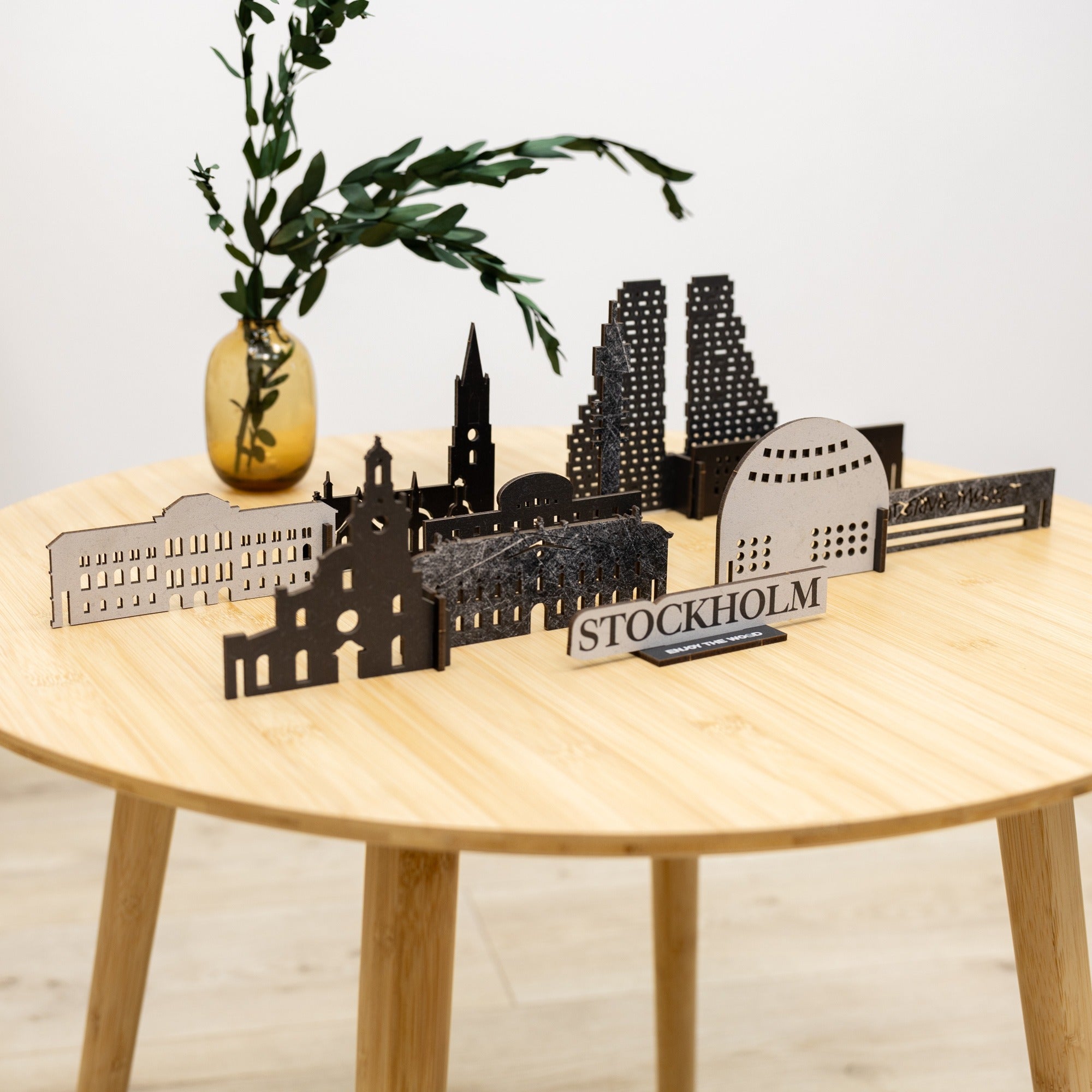 Model of Stockholm skyline on a wooden table with a vase and plant.
