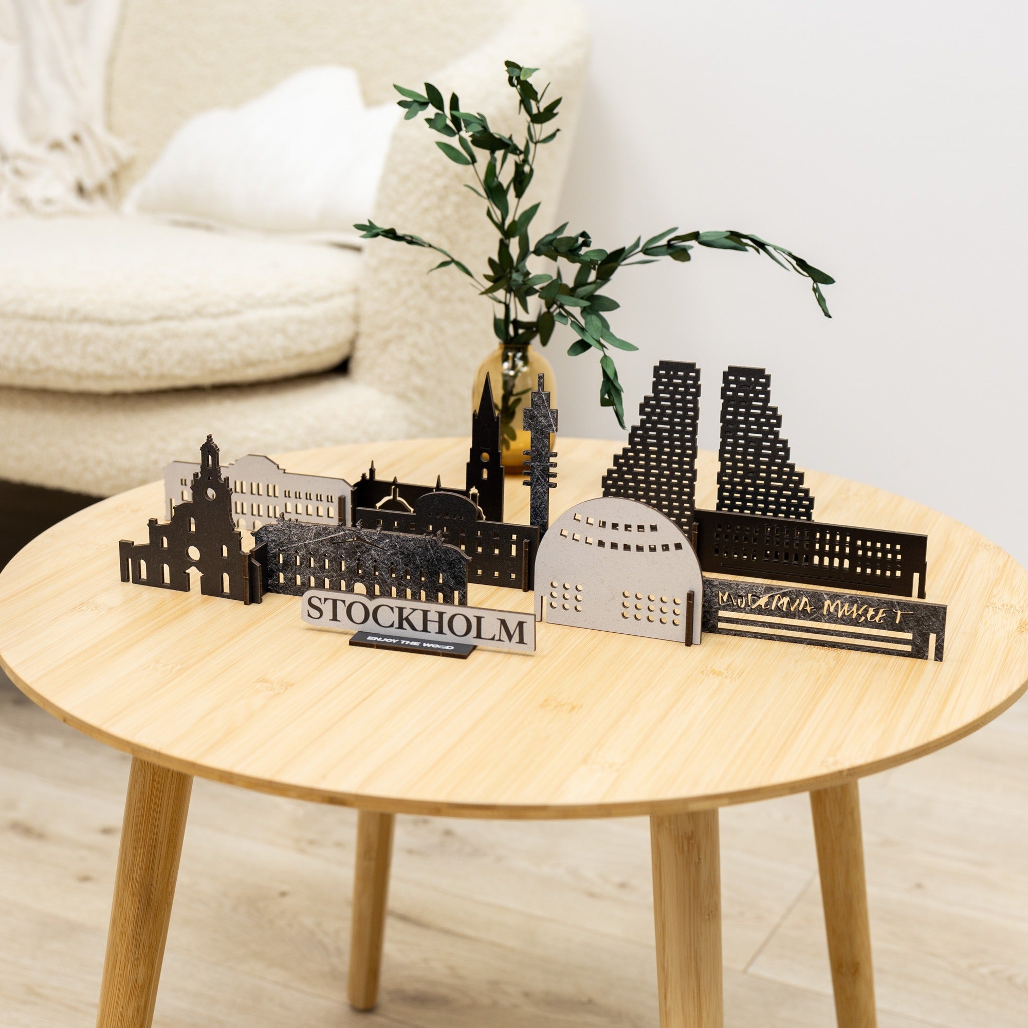 Model of Stockholm landmarks on a wooden table with a plant and chair in the background