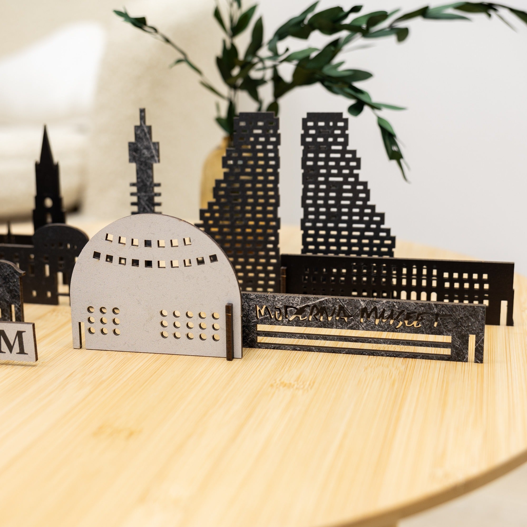 Model of a city skyline with architectural structures on a wooden surface.