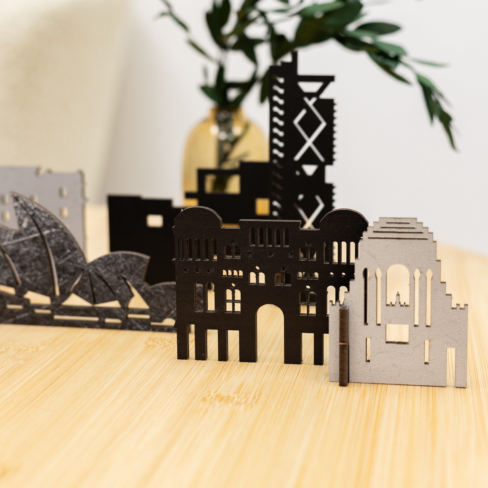Model of a cityscape with architectural structures on a wooden surface.