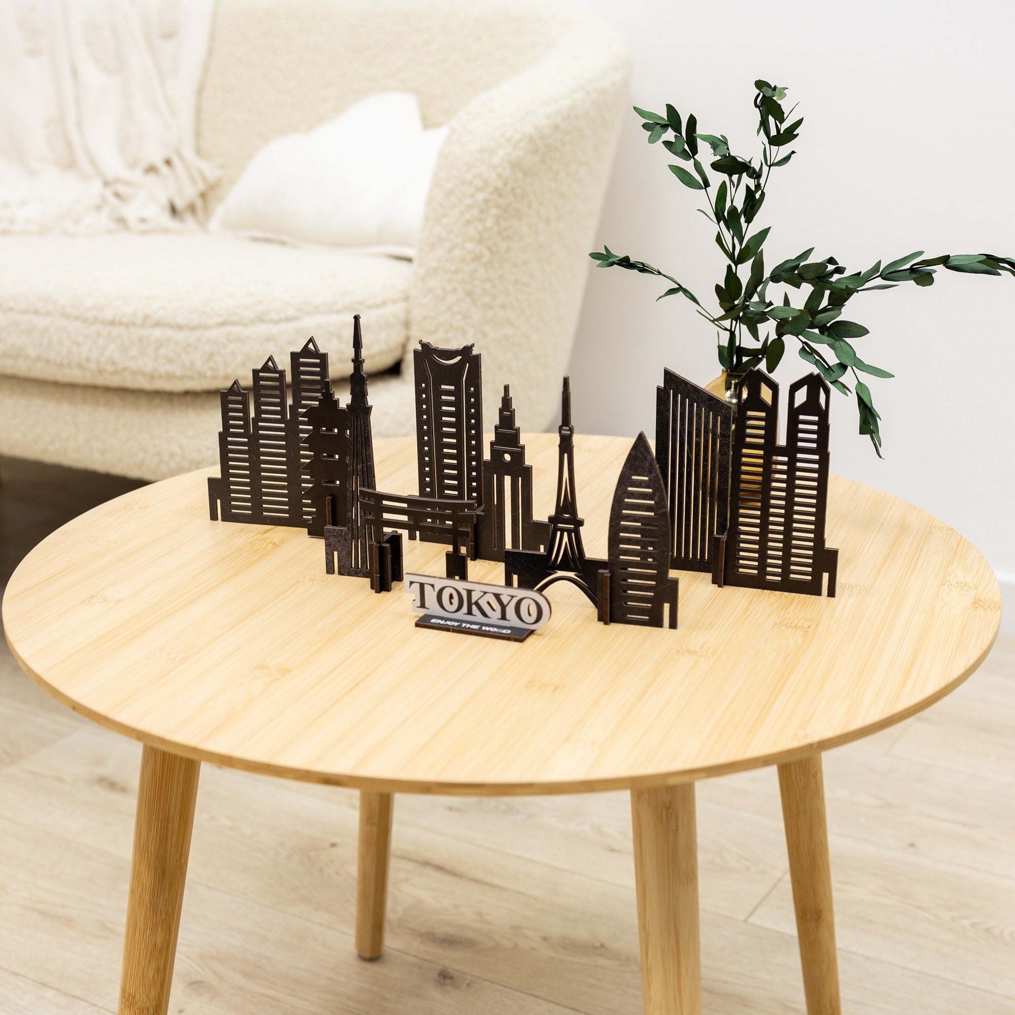 Model of Tokyo skyline on a wooden table with a plant and white chair in the background