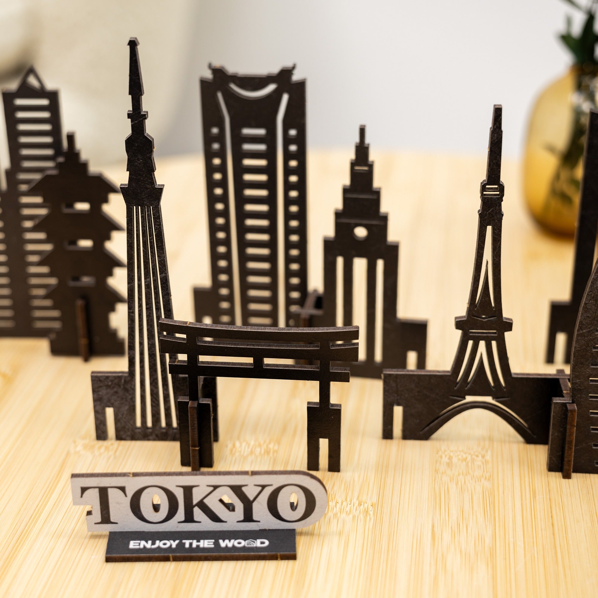 Model of Tokyo skyline with Eiffel Tower and other landmarks on a wooden surface.