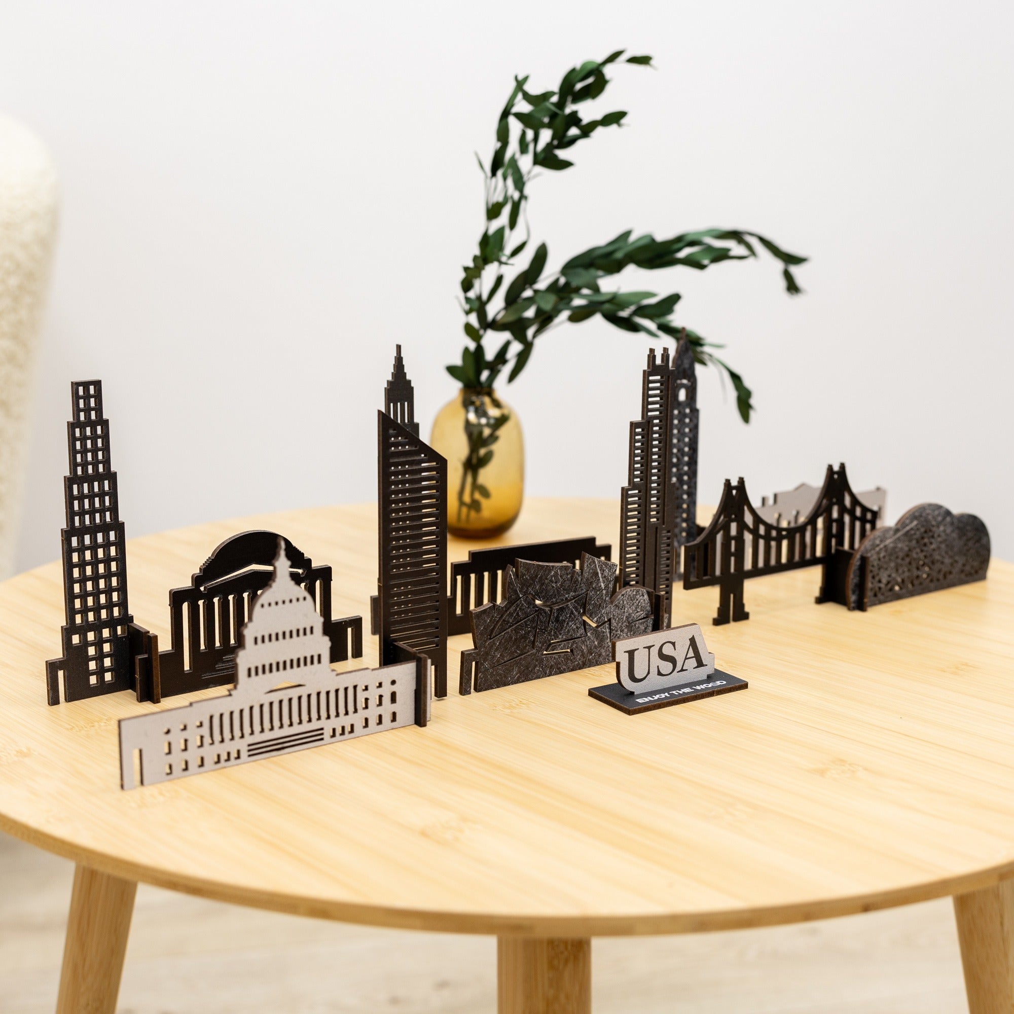 Model of a city skyline on a wooden table with a plant in the background