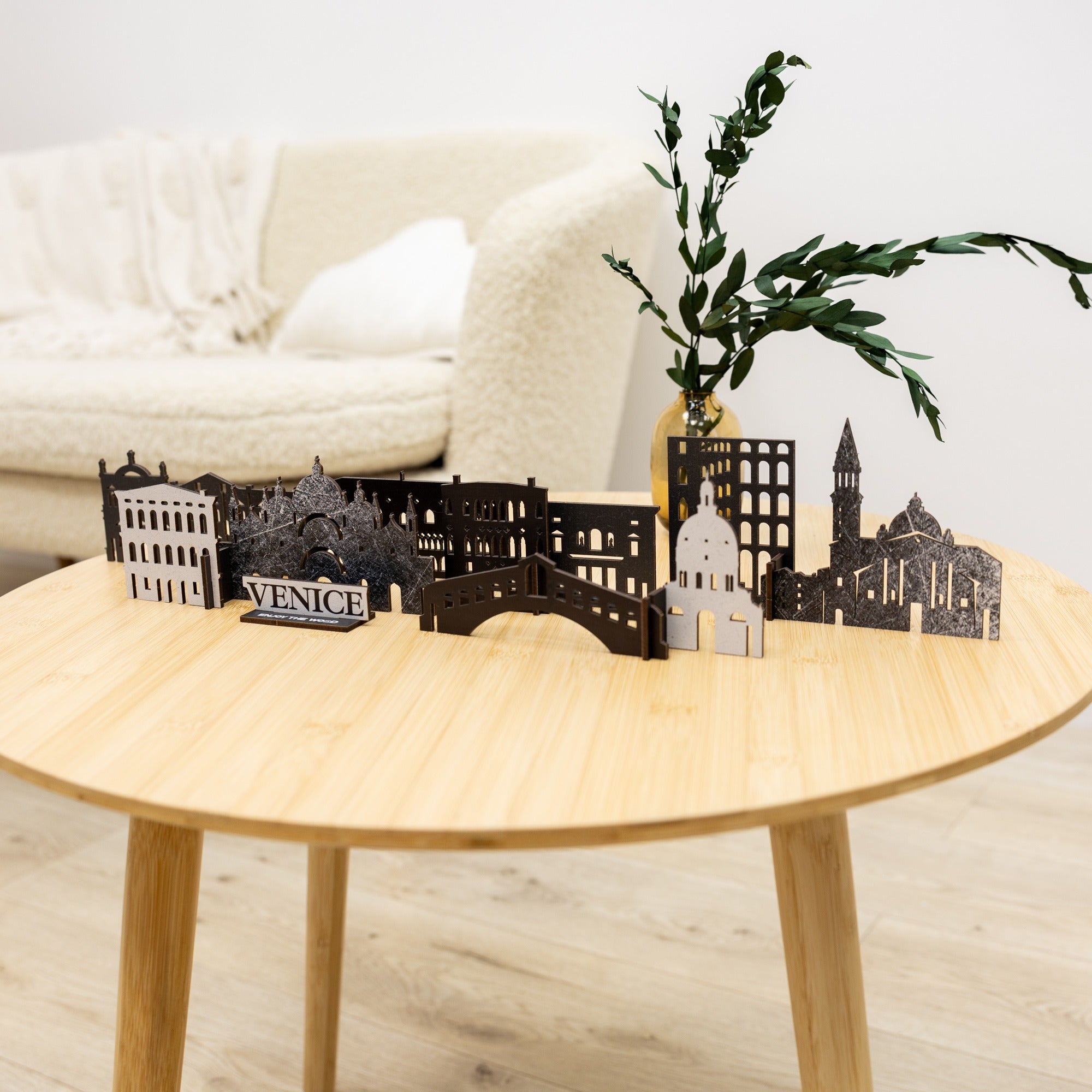 Model of Venice on a wooden table with a white sofa and plant in the background