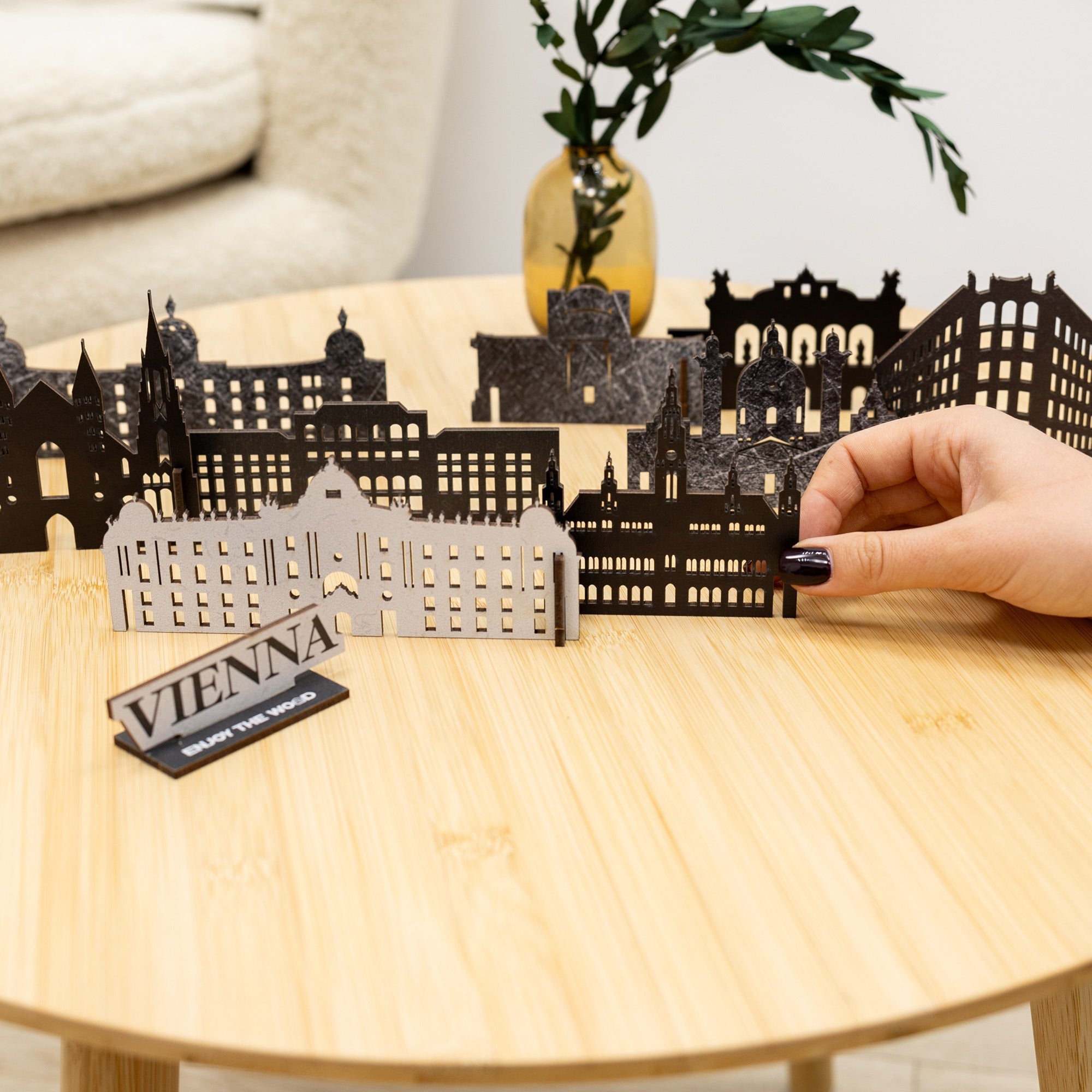 Model of a city skyline with 'Vienna' sign on a wooden table