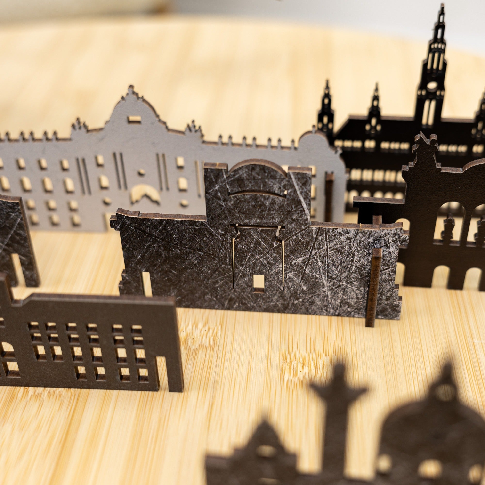 Shadow play with architectural cutouts on a wooden surface