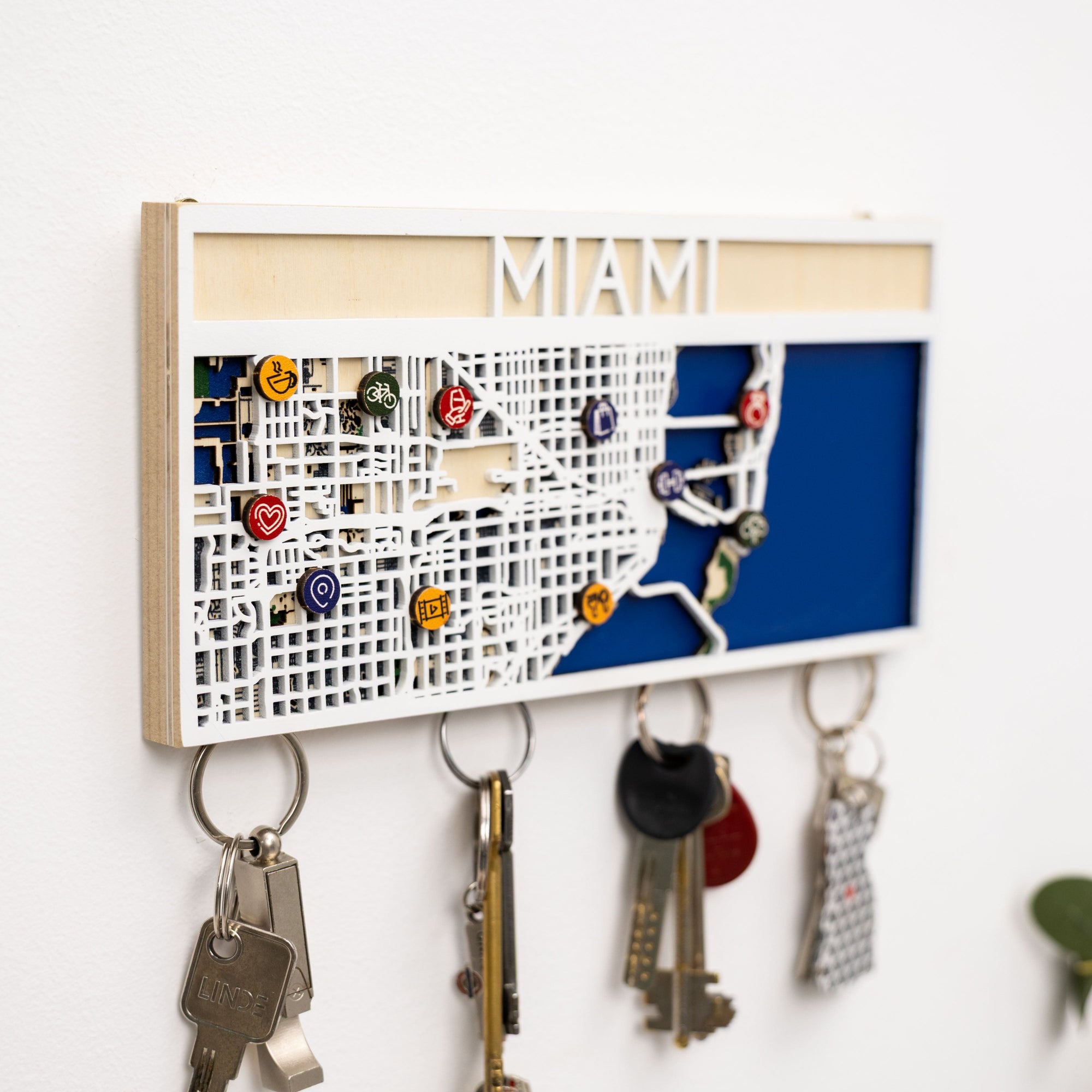 Key holder with a map of Miami and various keys attached, on a white background
