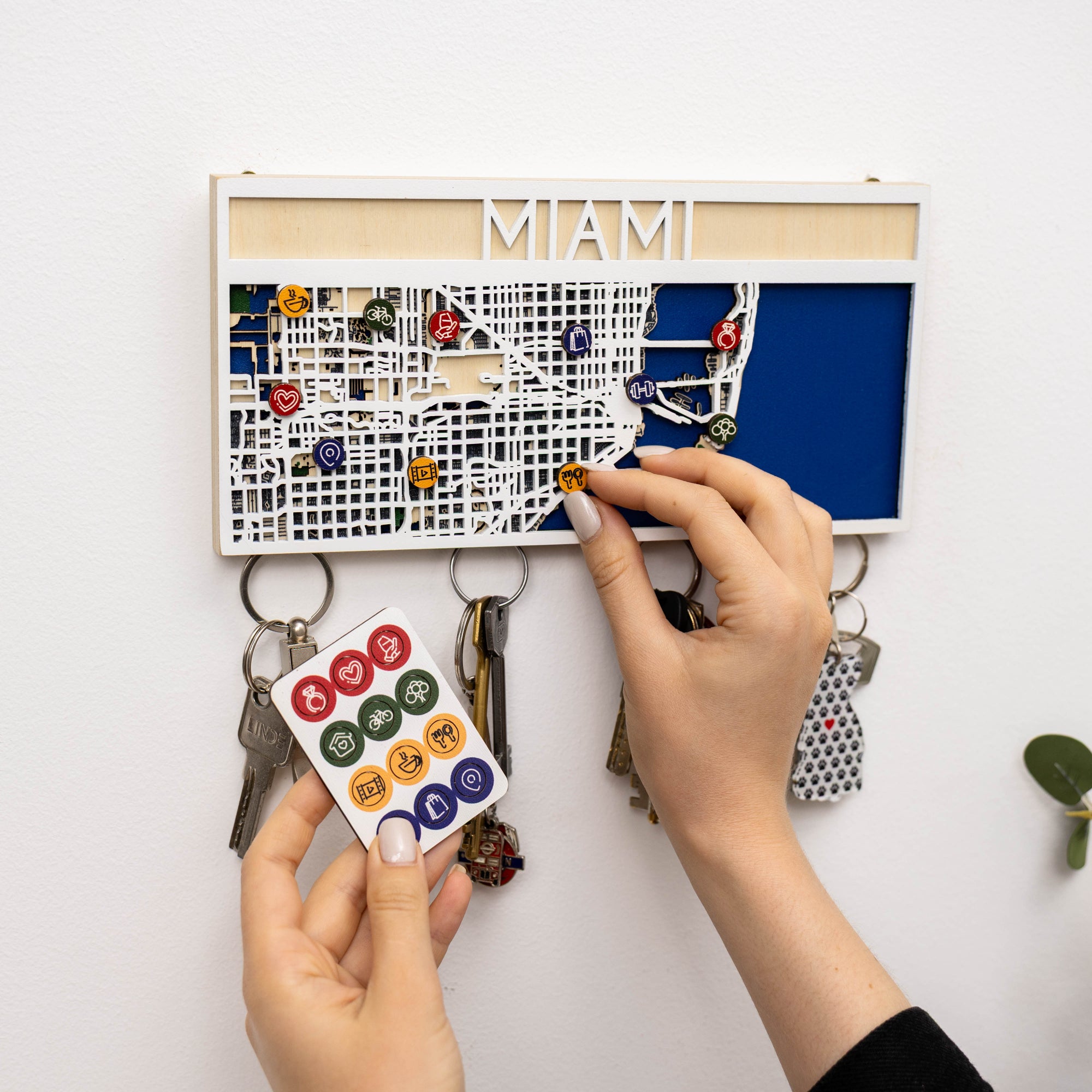 Person using a key holder with 'MIAMI' on a white background