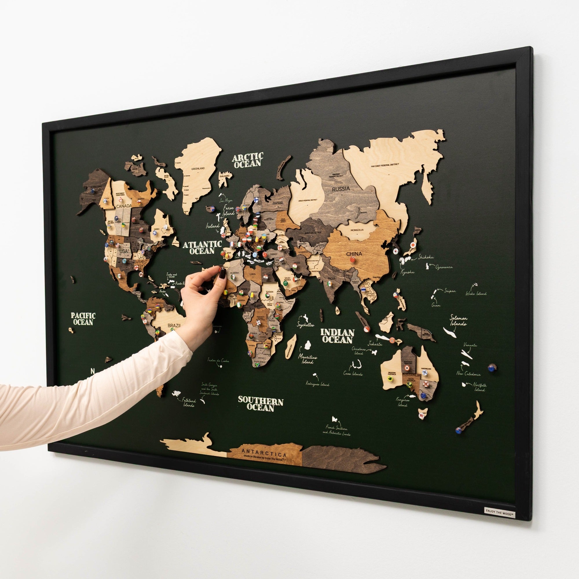 World map puzzle with a hand reaching to place a piece on a white background