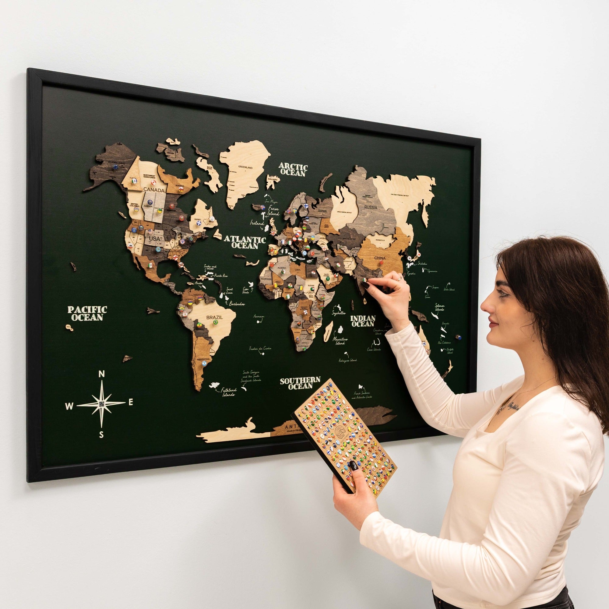 Woman interacting with a world map poster on a wall