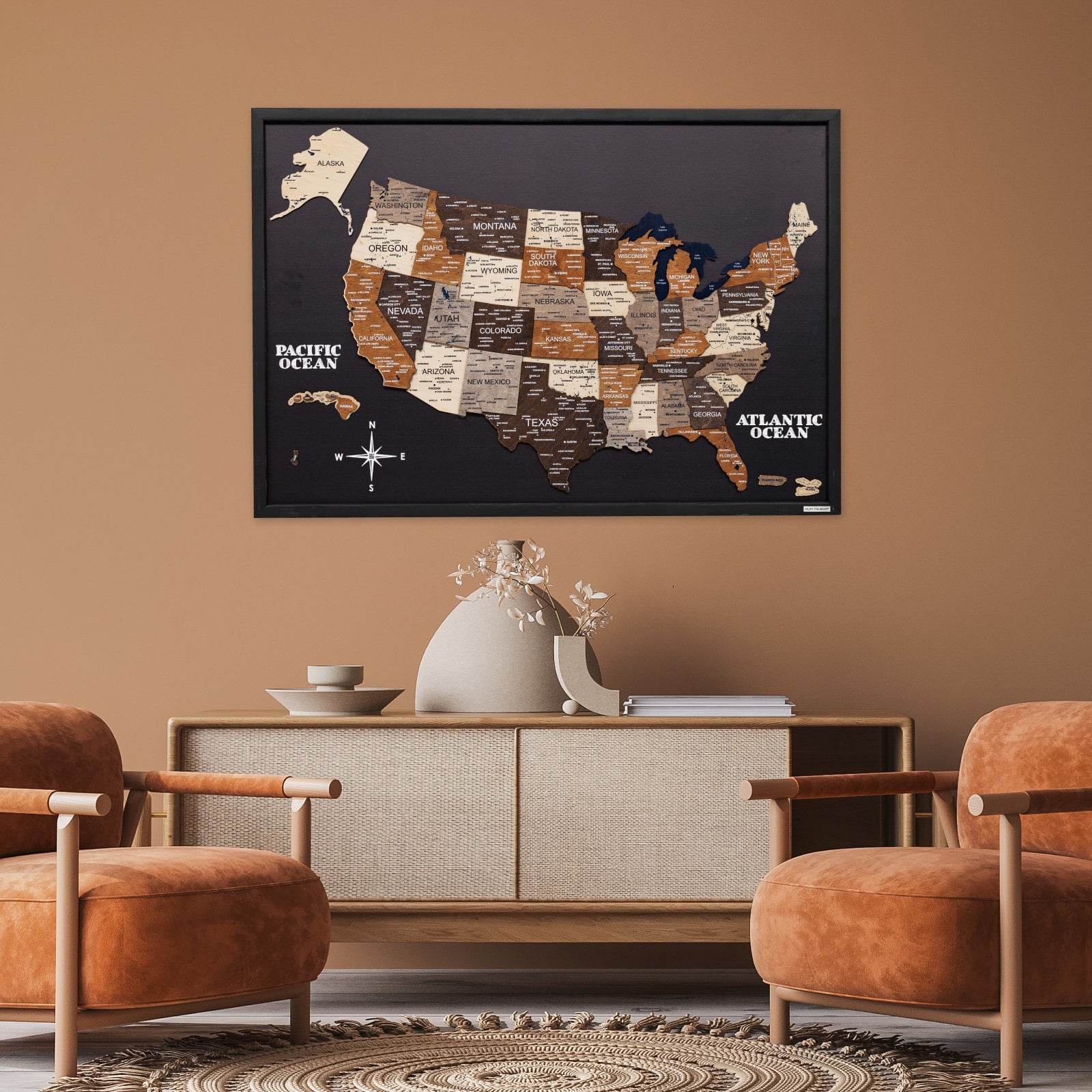 Framed map of the United States on a wall above a wooden cabinet with two chairs.