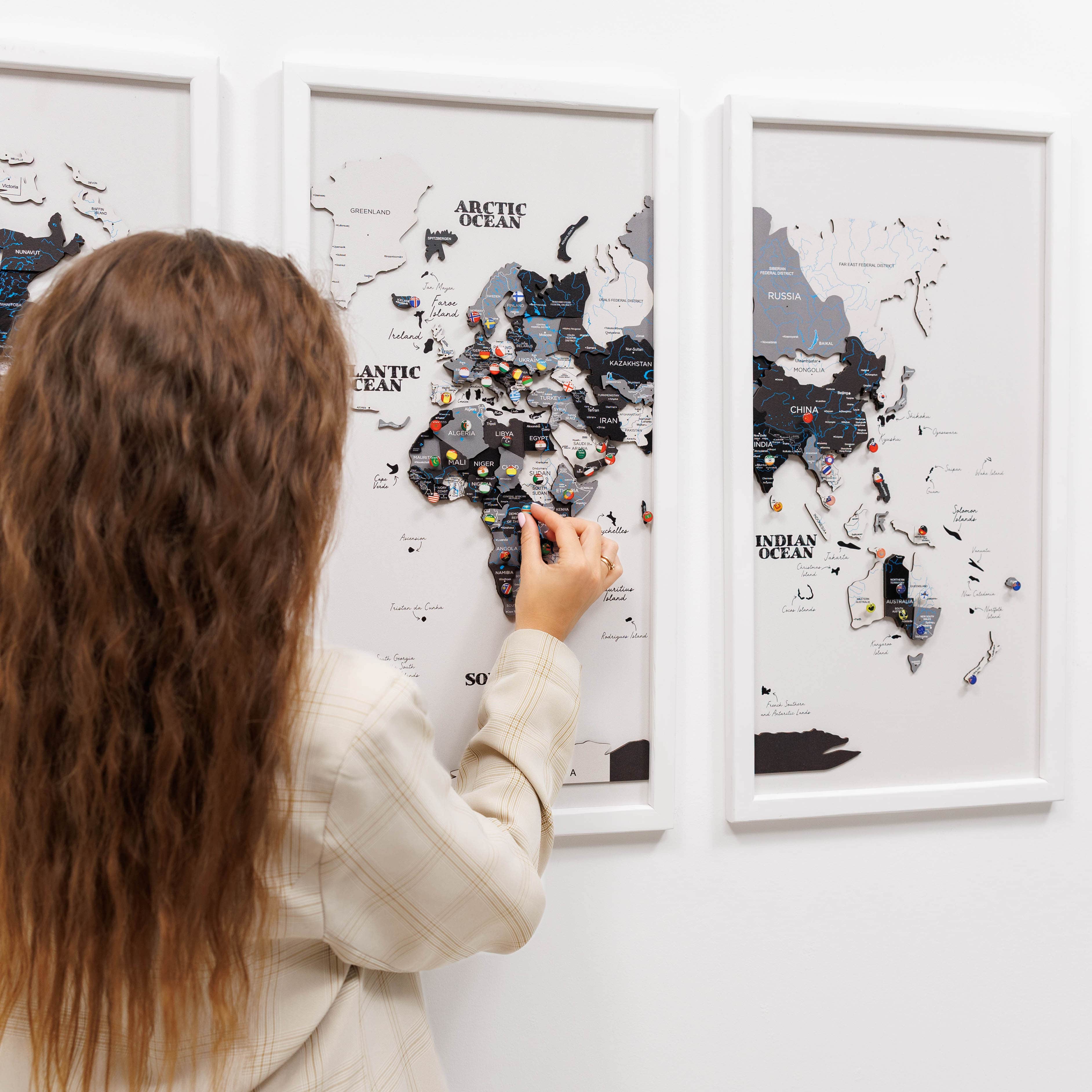 Woman interacting with a map of the world on a wall