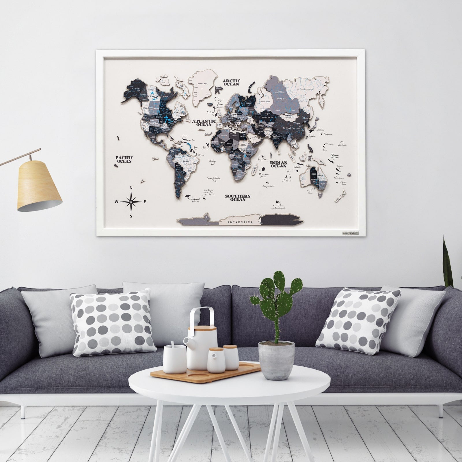 World map poster on a wall above a gray sofa in a living room.