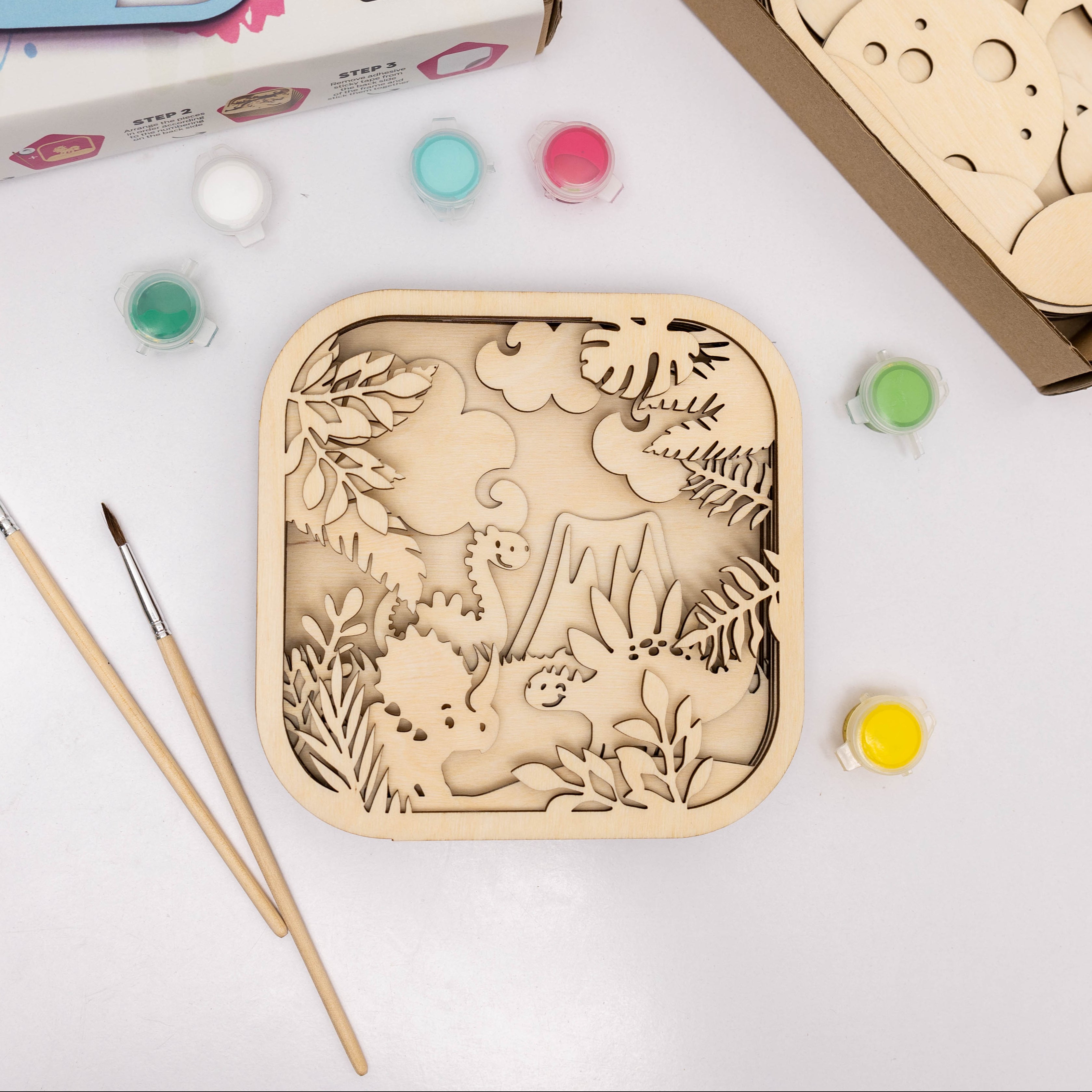 Wooden craft kit with paint and brushes on a white background
