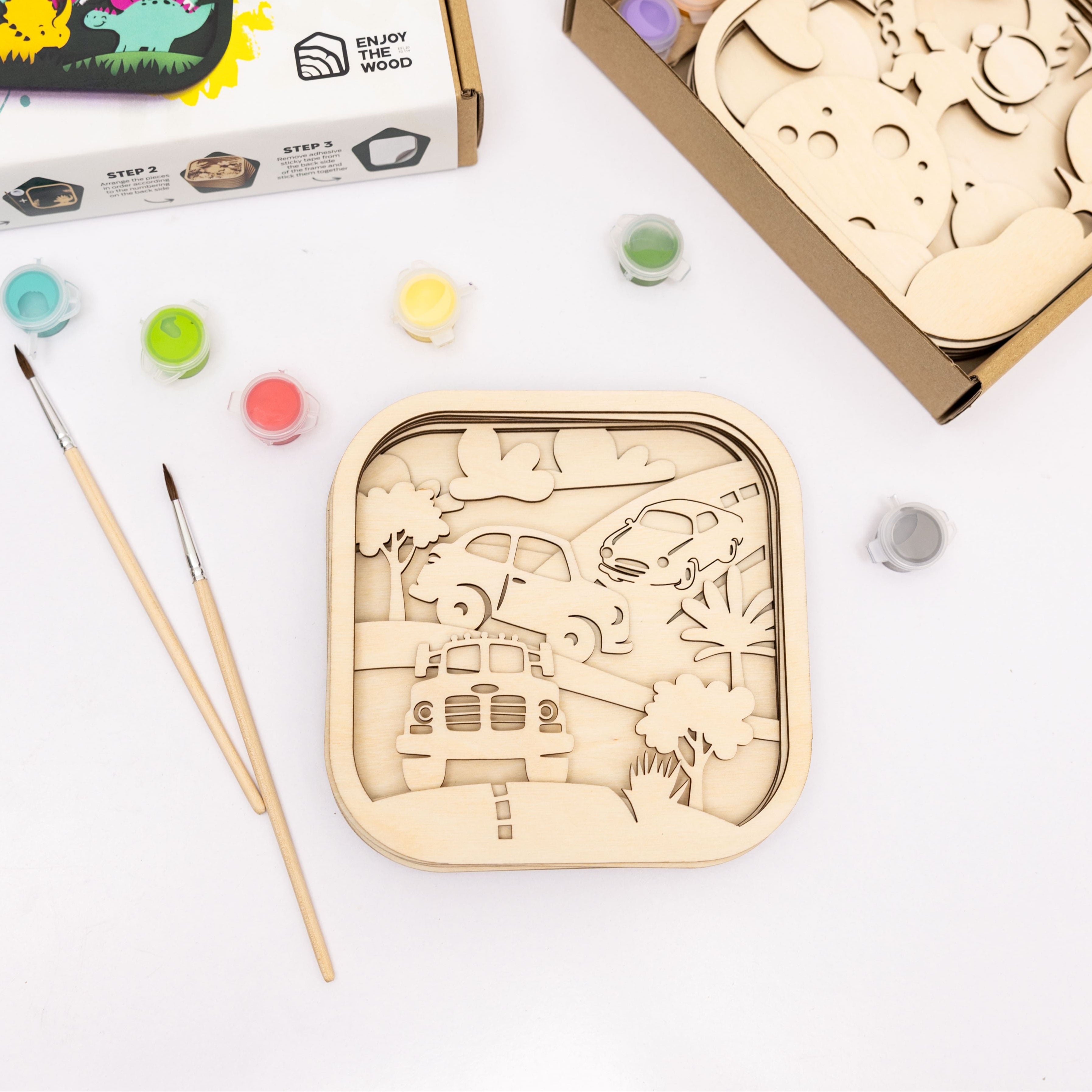 Wooden puzzle with paint and brushes on a white background