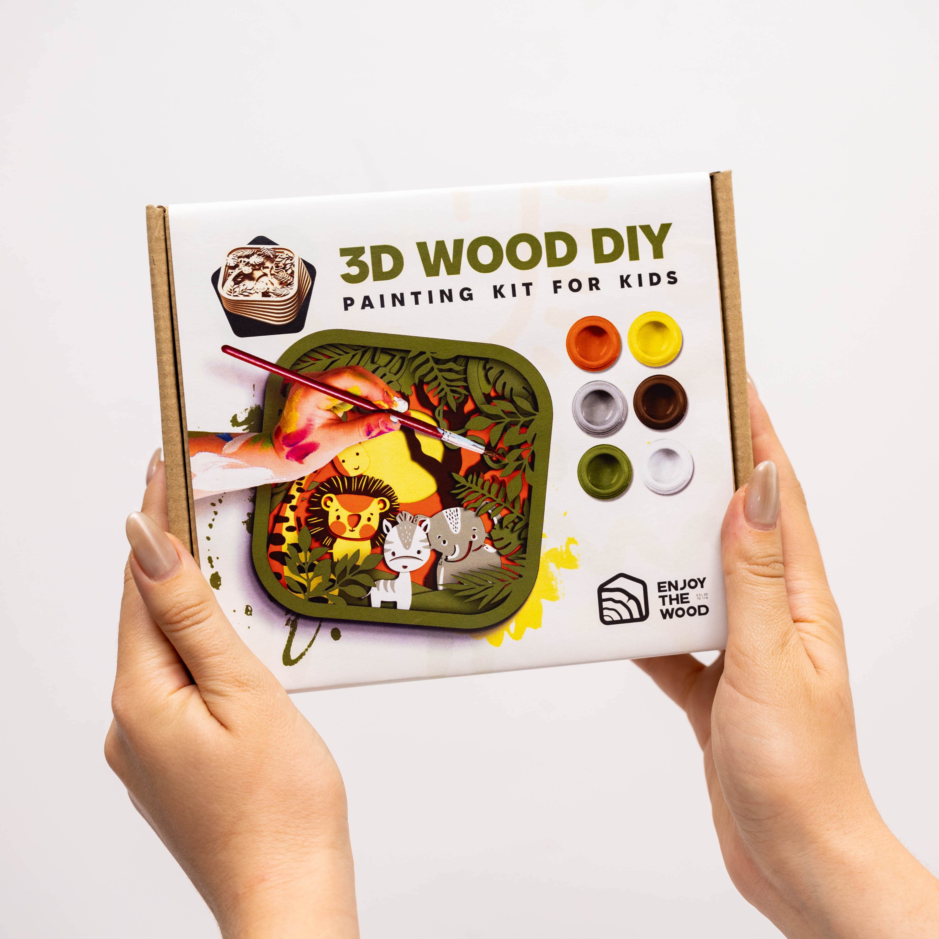 3D Wood DIY painting kit for kids held by hands on a white background
