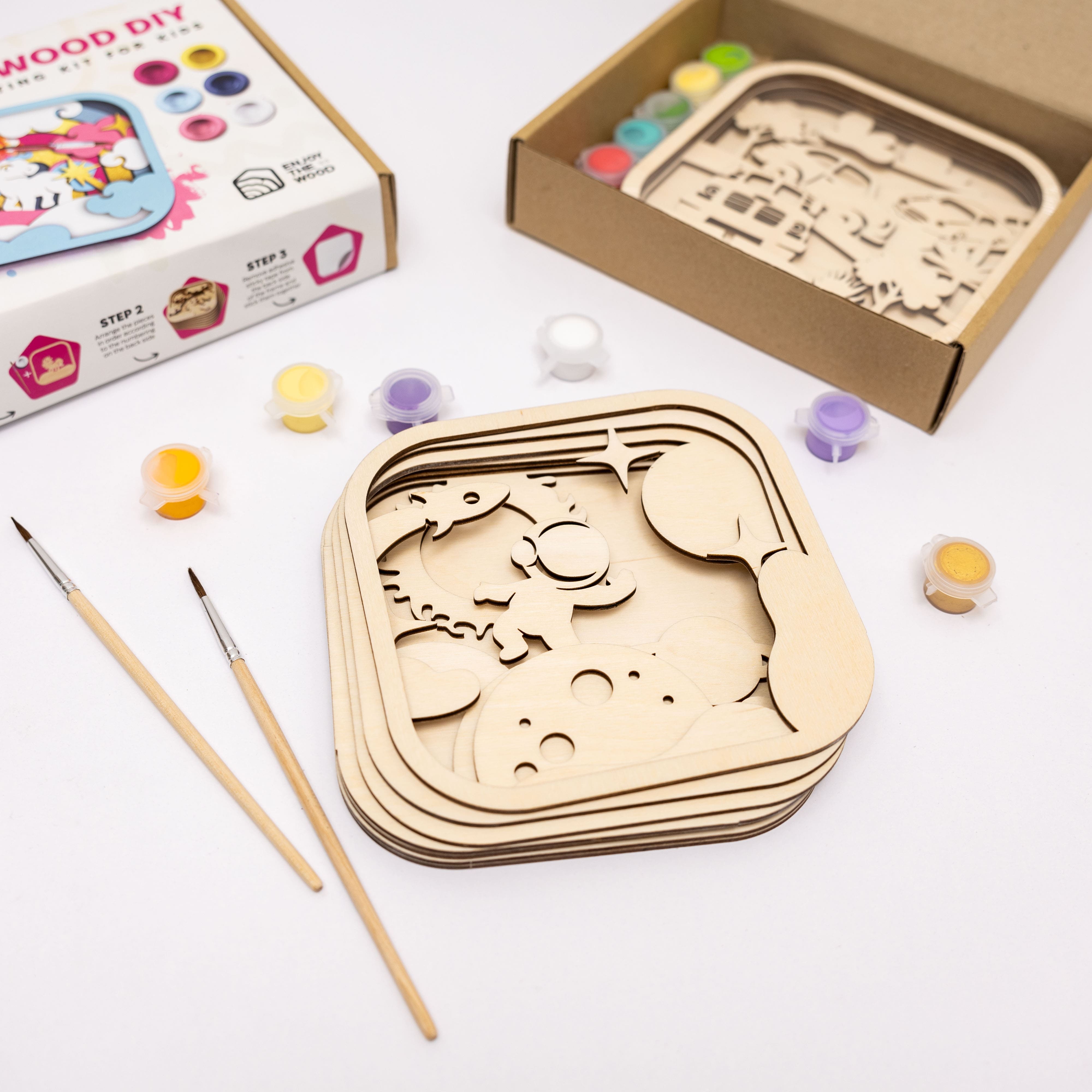 Wooden craft kit with paint and brushes on a white background